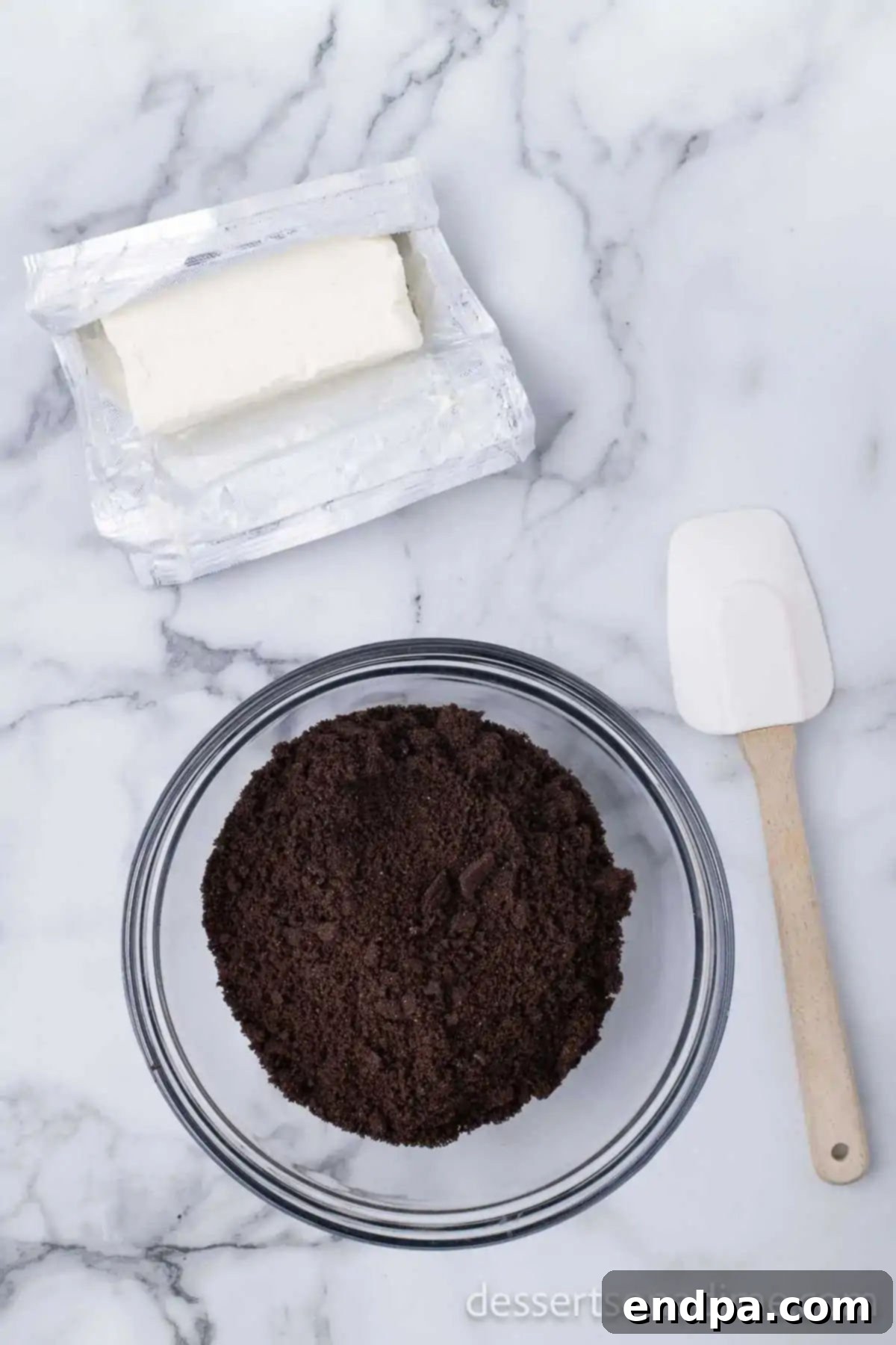 Irresistible Holiday Oreo Truffles 5 Softened cream cheese and crushed Oreo cookies are mixed together in a bowl, beginning to form the truffle base.