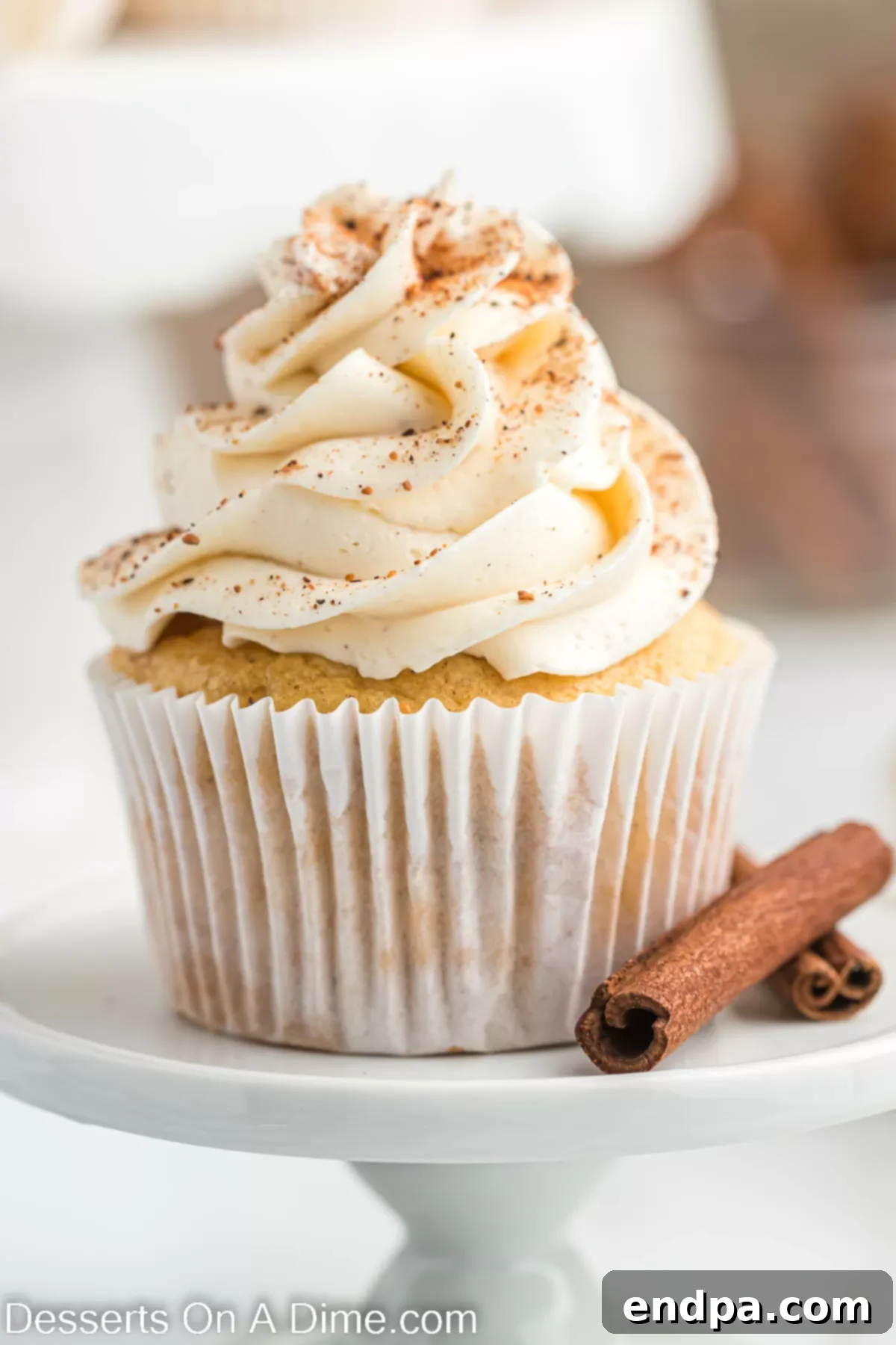 Festive Eggnog Cupcakes 14 Close-up of a perfectly frosted Eggnog Cupcake, garnished with nutmeg, showcasing its inviting texture and holiday appeal.