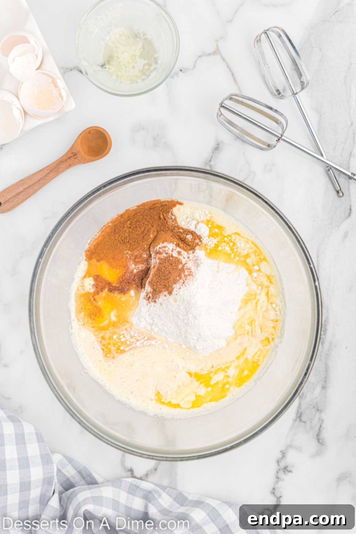 Festive Eggnog Cupcakes 4 A mixing bowl containing all the combined batter ingredients for Eggnog Cupcakes, being mixed with an electric mixer.