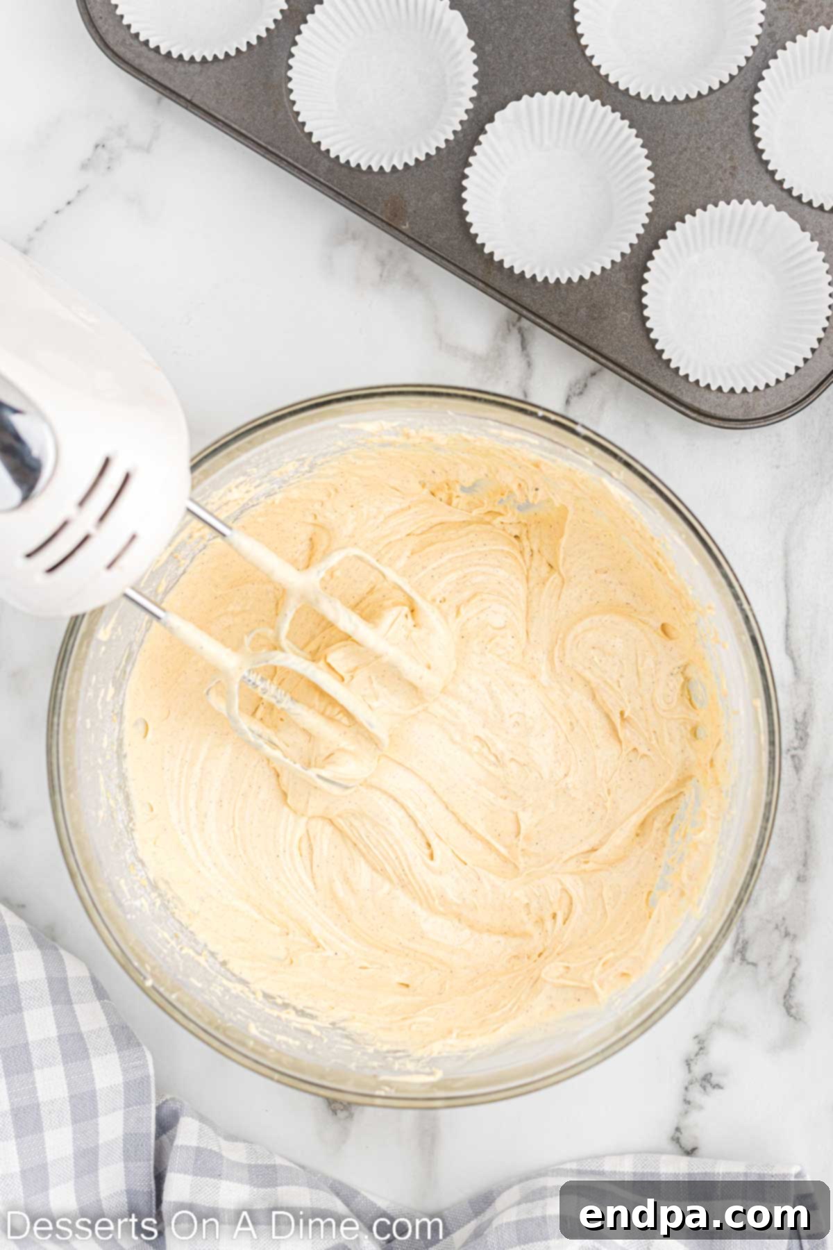 Festive Eggnog Cupcakes 5 Smooth, light yellow cupcake batter in a mixing bowl, ready to be divided into muffin tins.