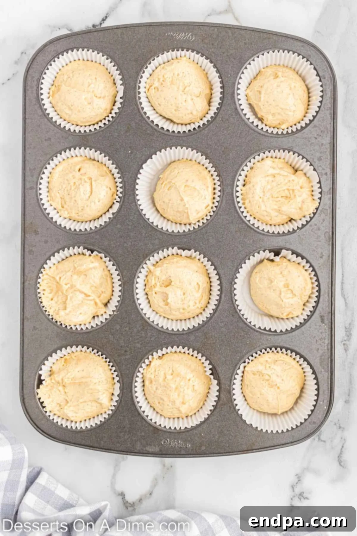 Festive Eggnog Cupcakes 6 Cupcake batter carefully divided into lined muffin tins, showing proper filling level.