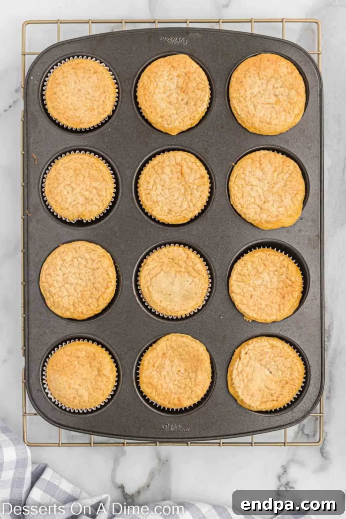 Festive Eggnog Cupcakes 7 Freshly baked Eggnog Cupcakes, golden brown and perfectly risen, cooling in a muffin tin.