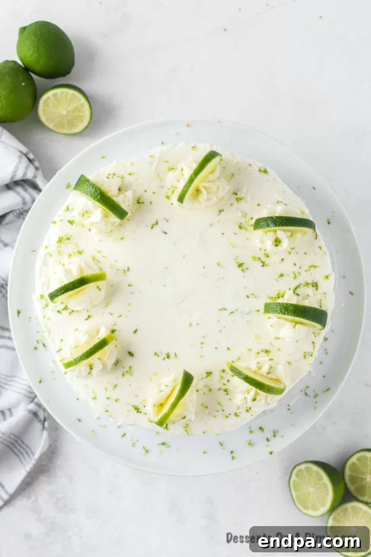 Margarita cake on cake stand, garnished with lime slices.