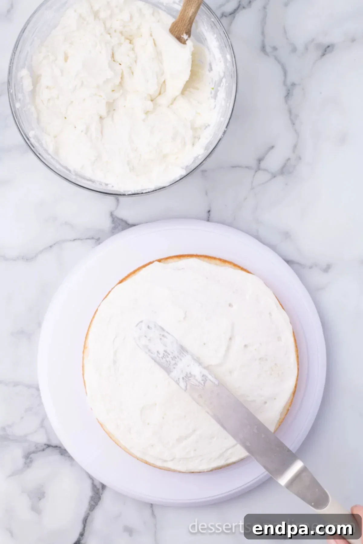 First layer of Margarita cake frosted on a cake stand.