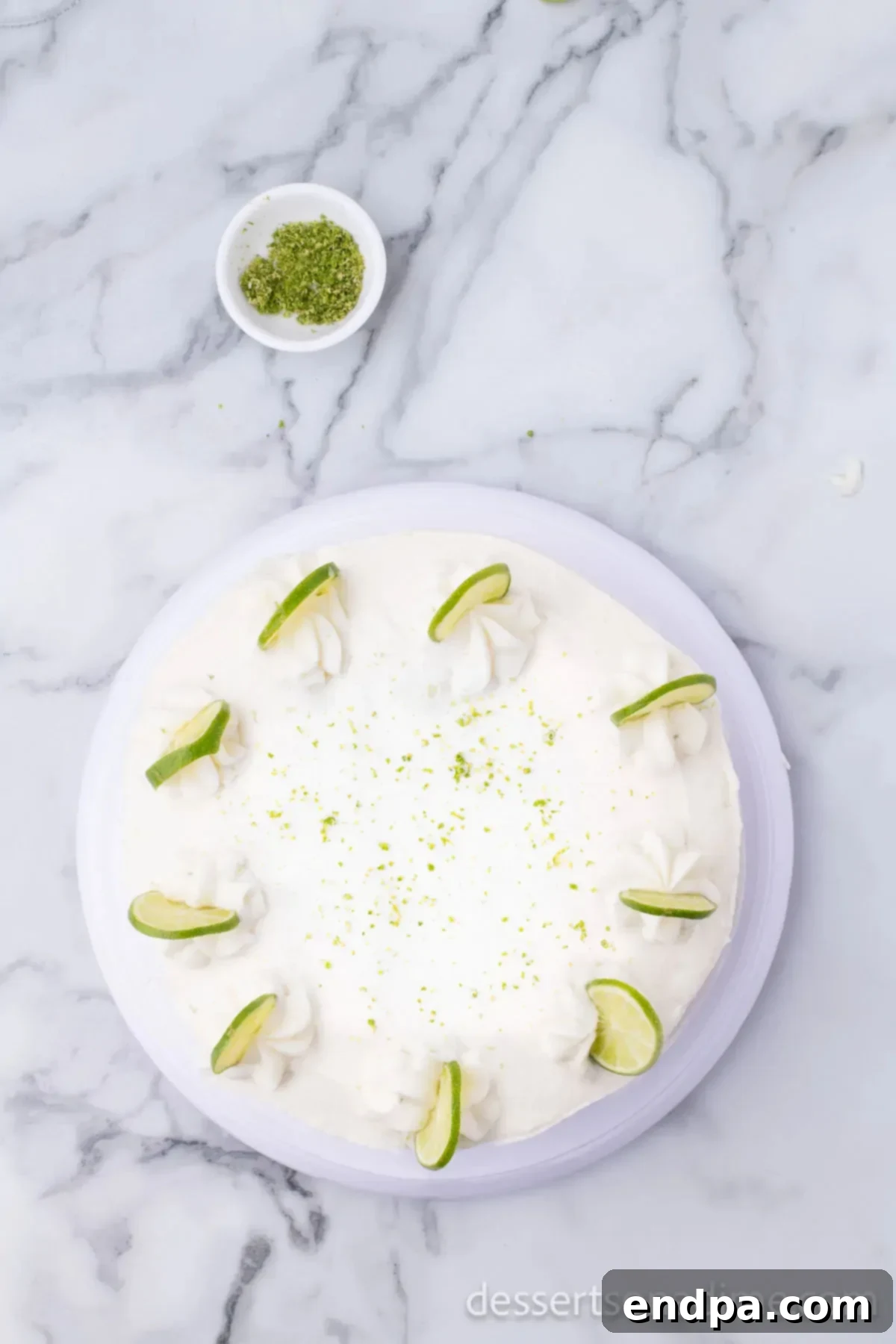 Margarita cake garnished with lime slices and fresh lime zest.