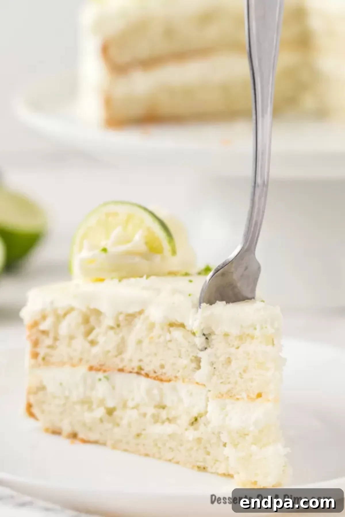 A slice of Margarita cake on a white plate with a fork.