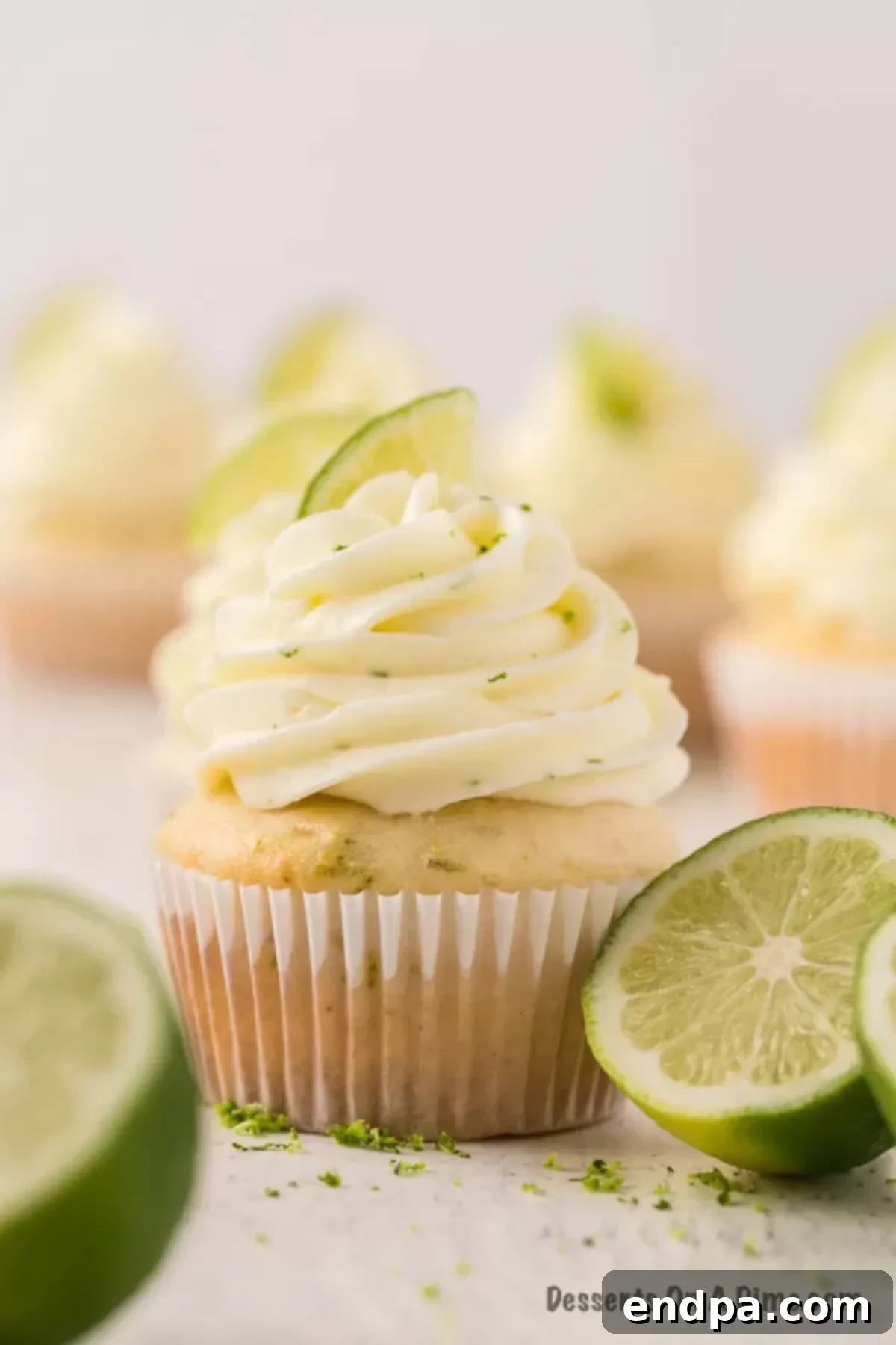 Tequila Lime Cupcakes 10 A close up image of margarita cupcakes with slices of fresh lime