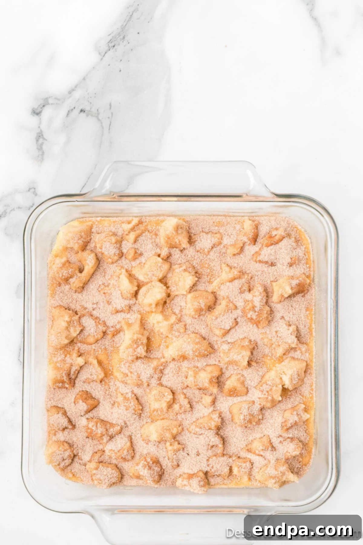 Irresistible Snickerdoodle Cheesecake Bars 11 The final touch: the remaining cinnamon sugar mixture is sprinkled evenly over the cookie dough pieces and cheesecake filling, ready for baking.