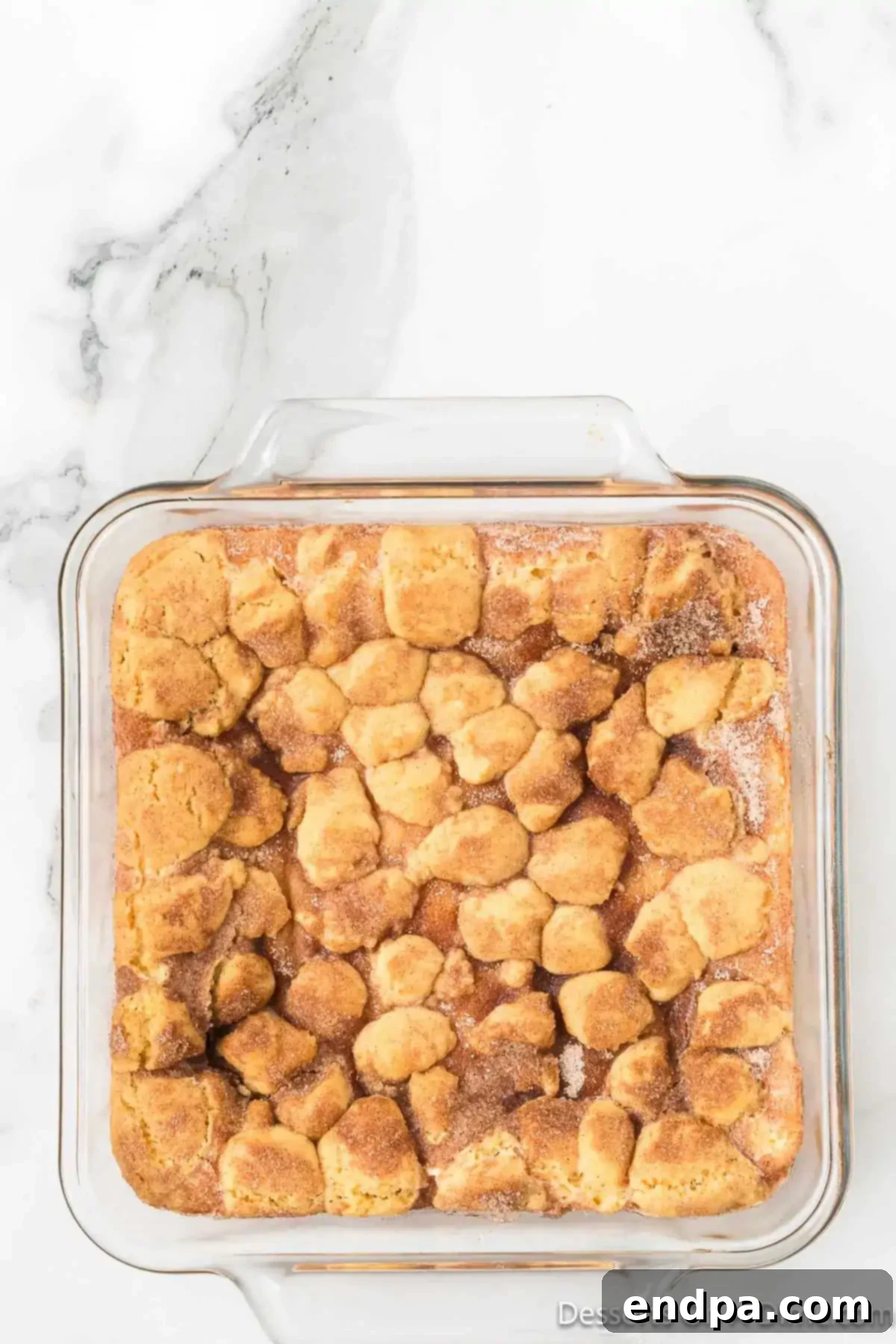 Irresistible Snickerdoodle Cheesecake Bars 12 The Snickerdoodle cheesecake bars, freshly baked to a beautiful light golden brown, showcasing a perfectly set center and a tempting crisp topping.