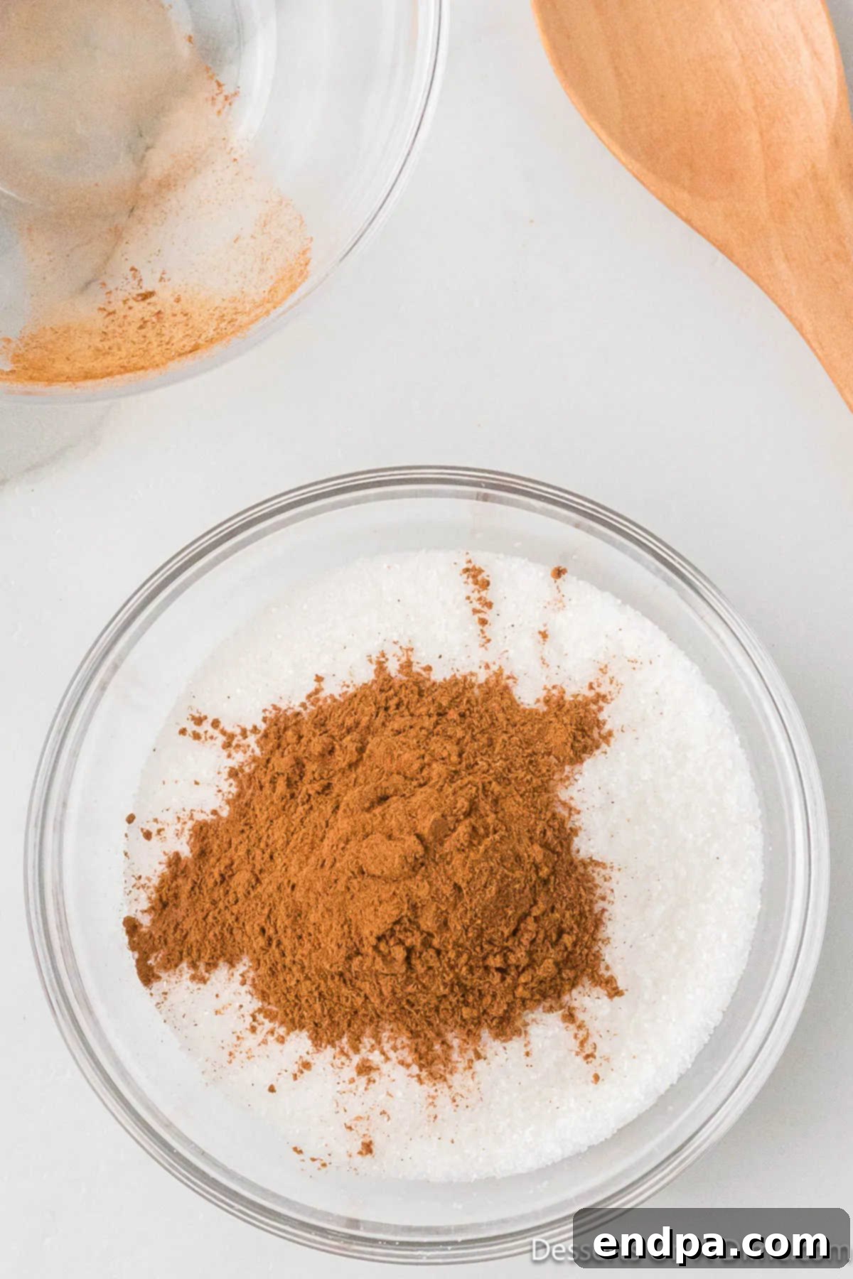 Irresistible Snickerdoodle Cheesecake Bars 7 A small bowl contains a simple yet fragrant mixture of ground cinnamon and granulated sugar, ready to be sprinkled on the Snickerdoodle layers.