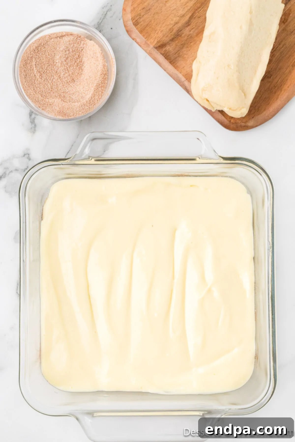 Irresistible Snickerdoodle Cheesecake Bars 9 The smooth and creamy cheesecake filling is carefully spread in an even layer over the cinnamon-sugar-dusted cookie dough crust.