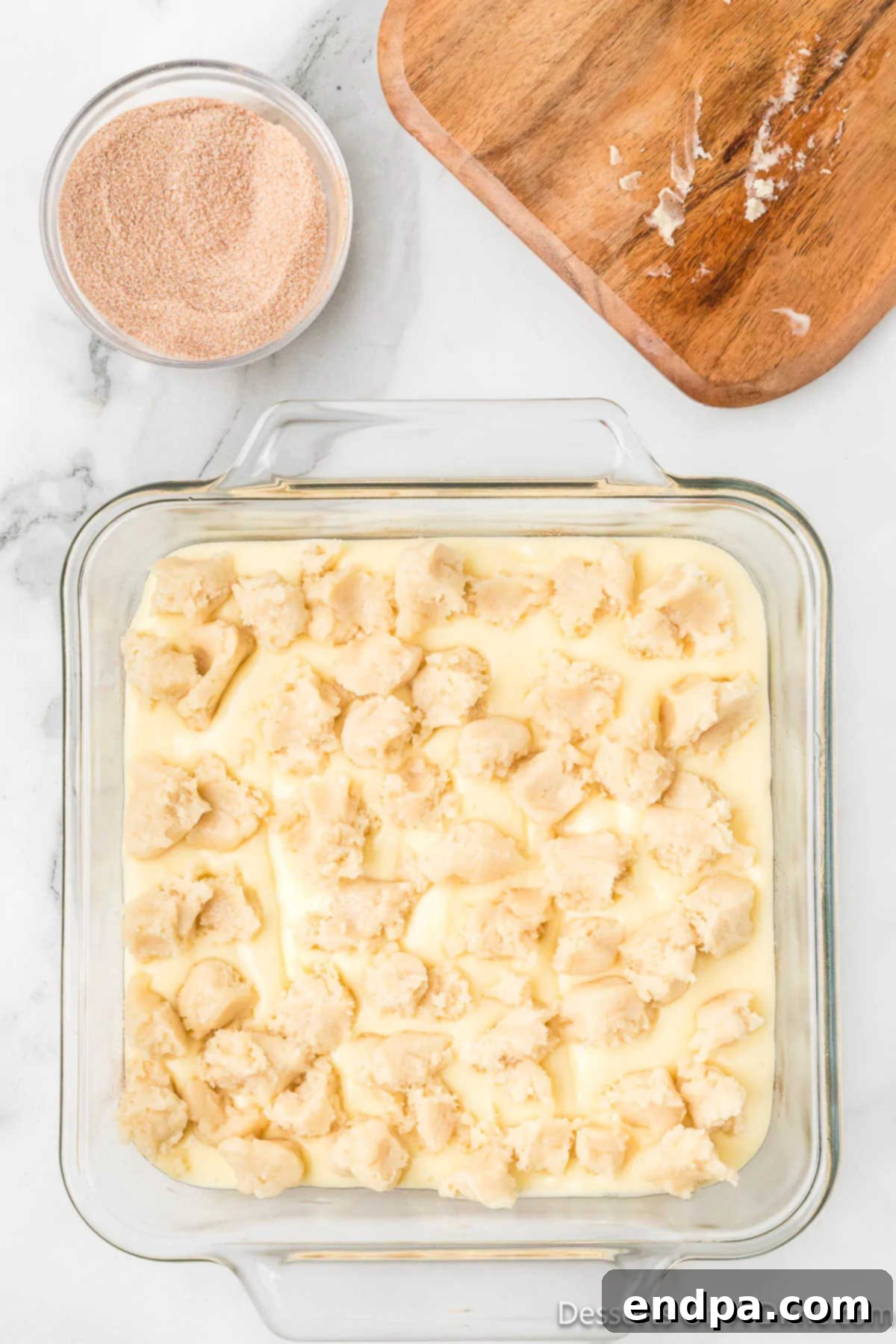 Irresistible Snickerdoodle Cheesecake Bars 10 Small, random pieces of the reserved sugar cookie dough are dropped artfully over the smooth cheesecake layer, forming a delightful topping.