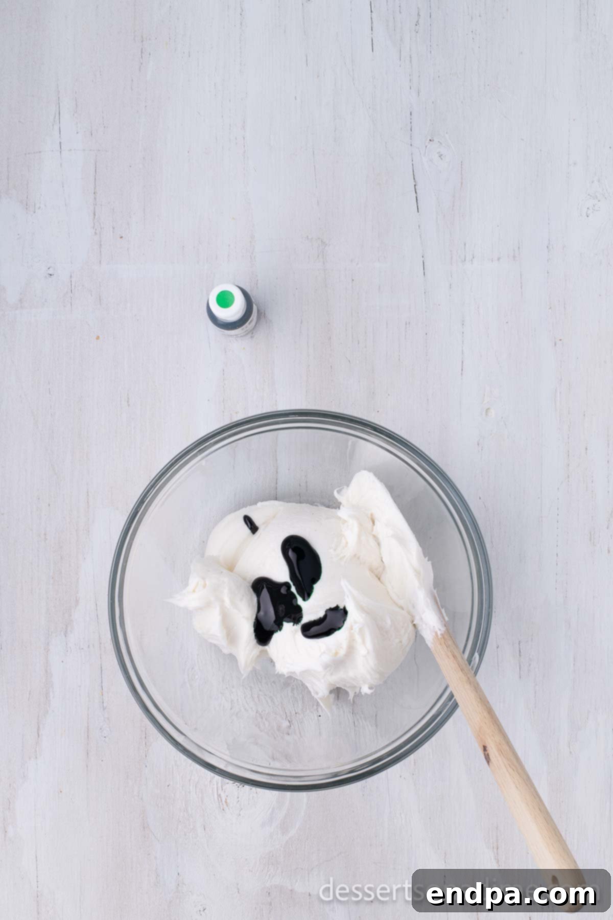 Bowl of white frosting with green food coloring added.