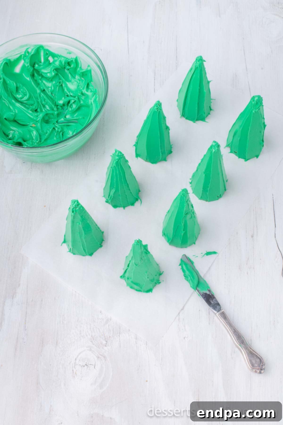 Icing being spread onto an ice cream cone.