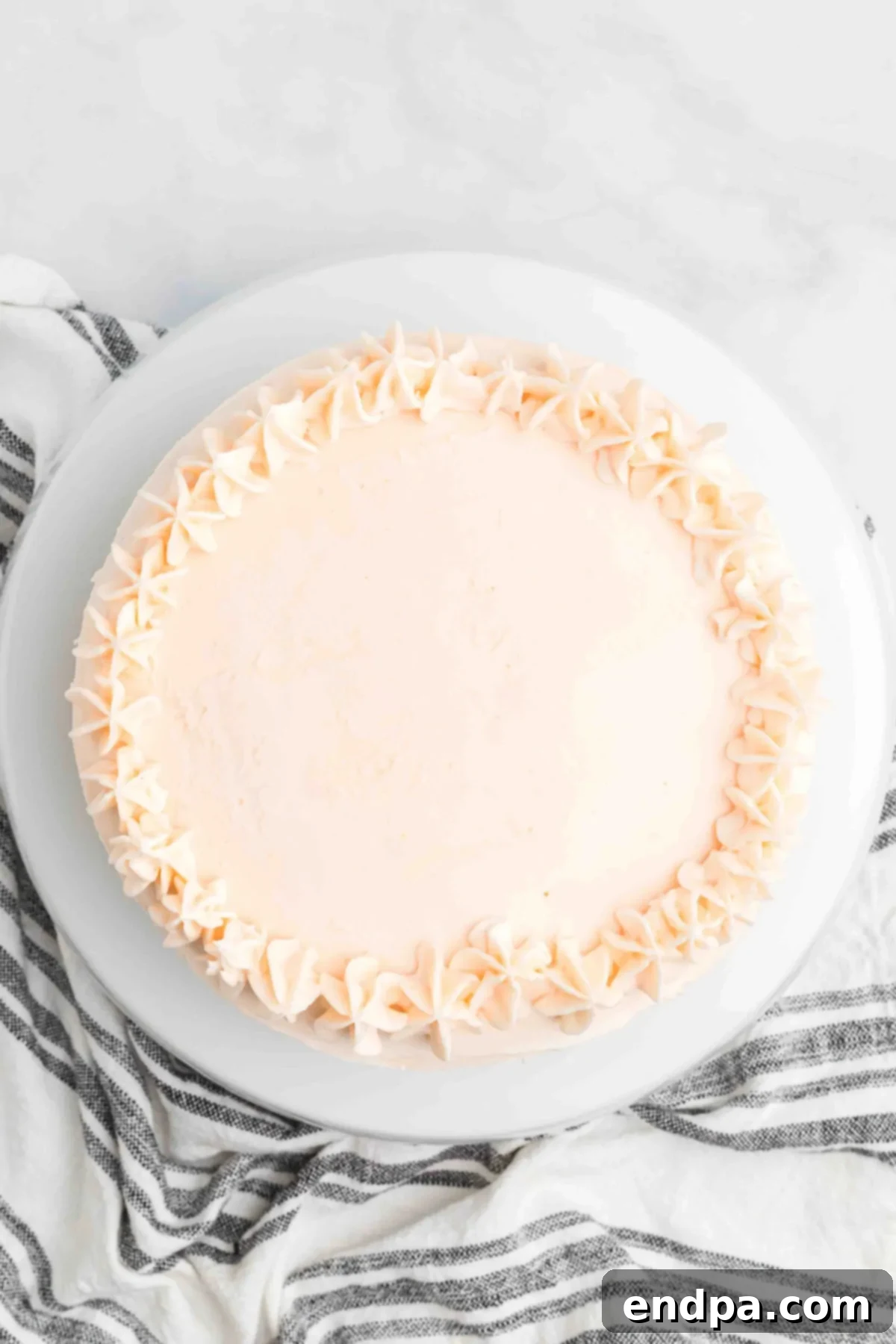 Cake on platter with frosting swirls.