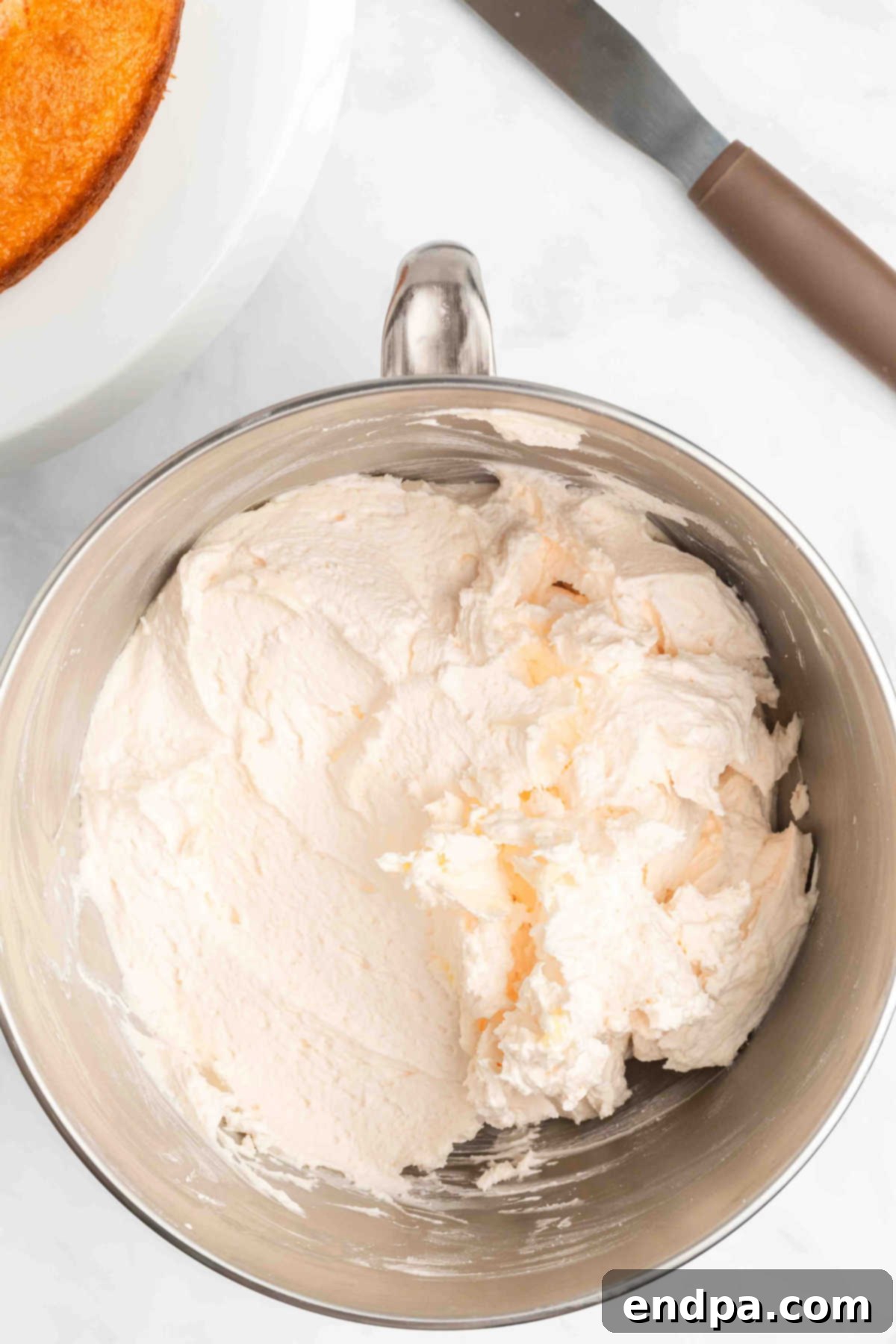 Mixer bowl with icing ingredients being combined.