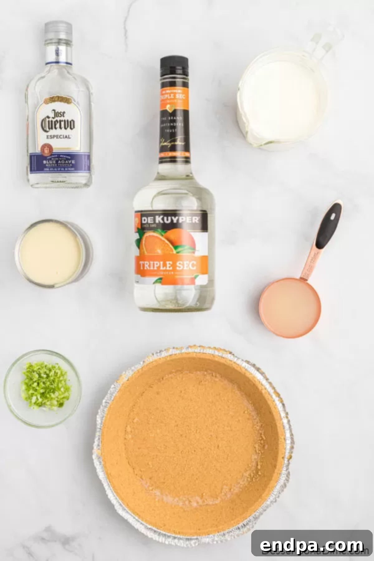 Ingredients for Margarita pie, including heavy cream, sweetened condensed milk, lime juice, lime zest, and a graham cracker crust.