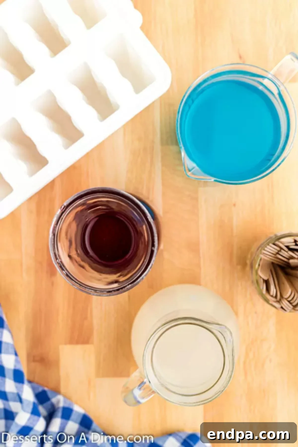 Ingredients for patriotic popsicles: cranberry juice for red, lemonade for white, and blue Gatorade for blue.