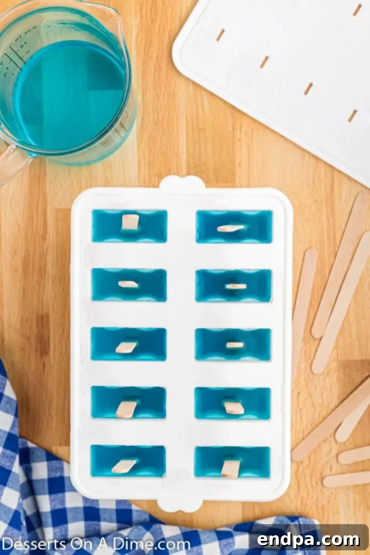 Third layer: Blue Gatorade is added on top, preparing for final freeze.
