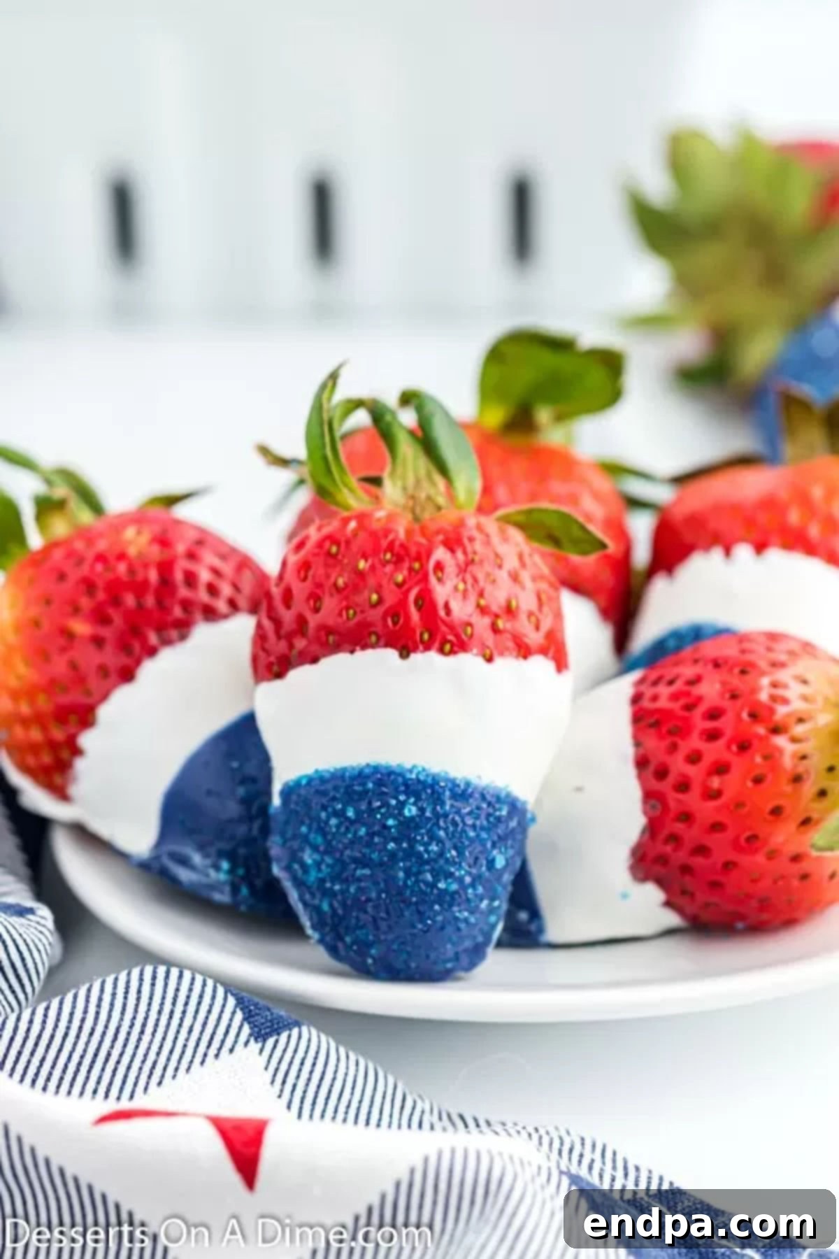 Platter of red, white, and blue strawberries arranged festively for a holiday gathering.
