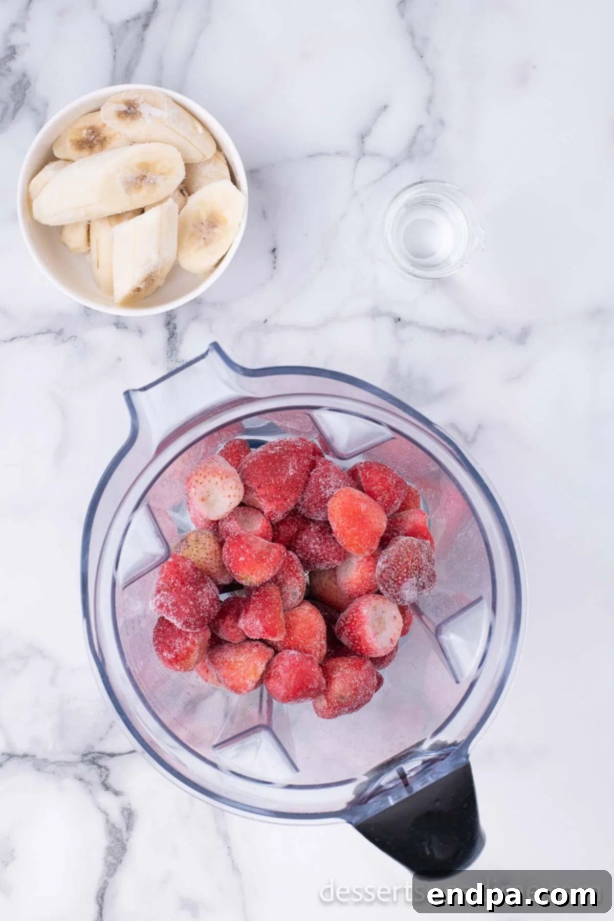 Fruity Frozen Delights 4 Frozen fruit and banana chunks placed inside a blender, ready for processing.