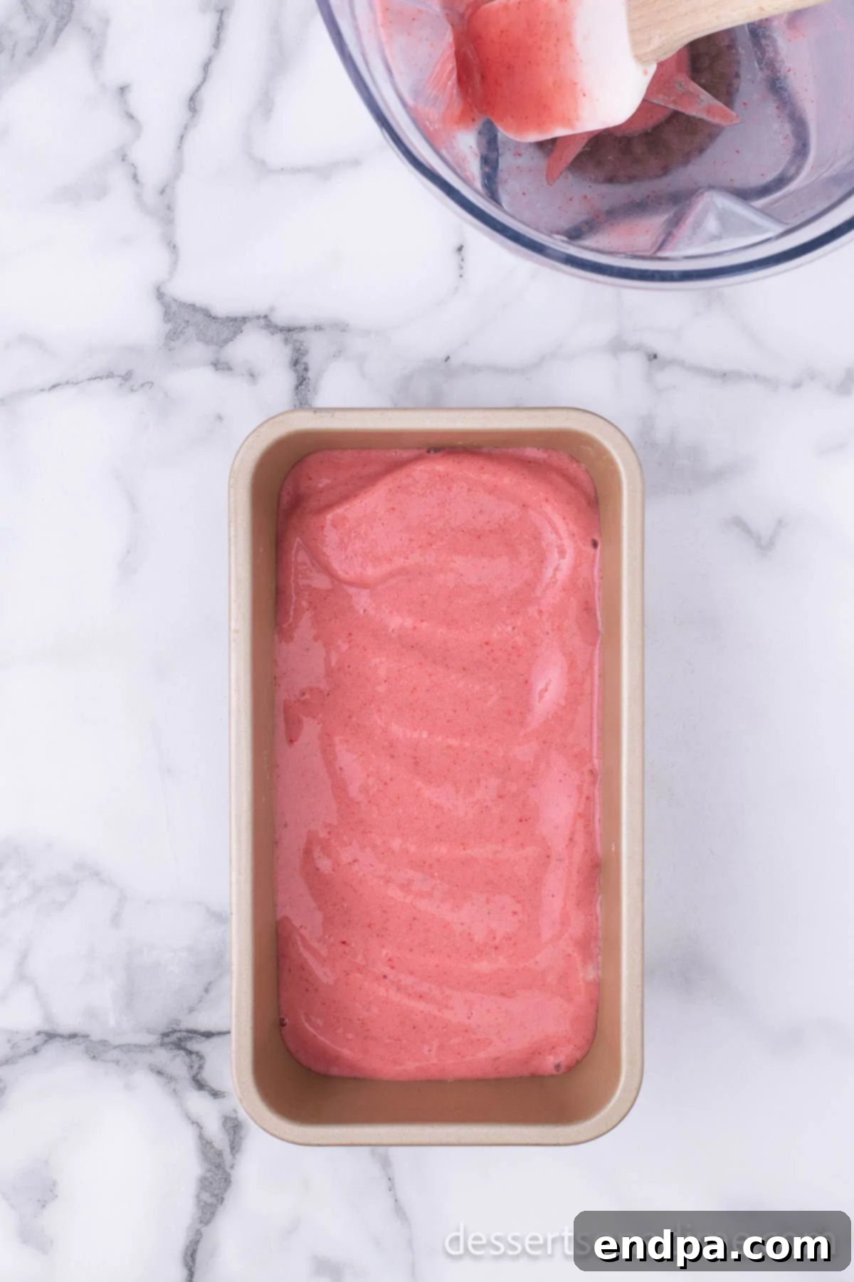 Fruity Frozen Delights 6 The blended fruit mixture being spread evenly into a loaf pan for freezing.