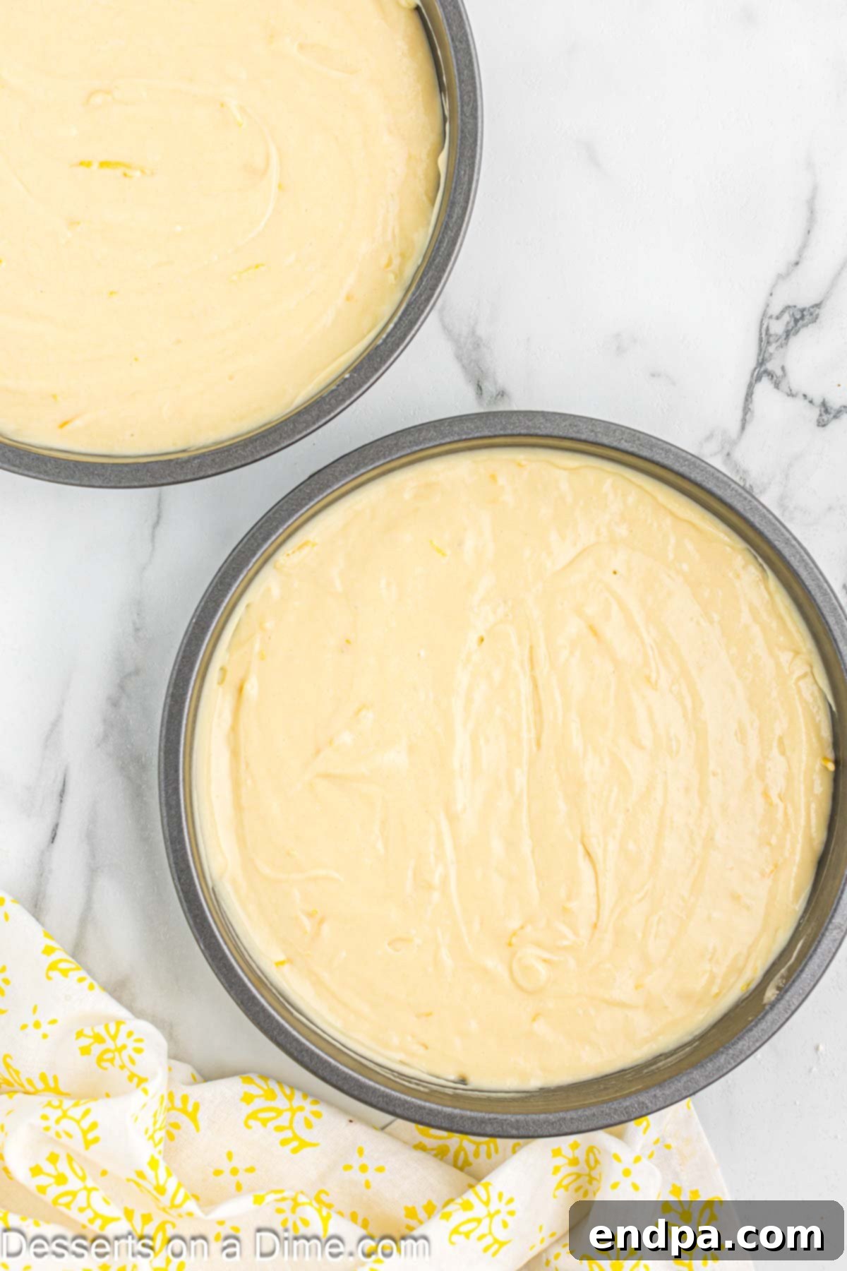 Sunshine Lemon Cake 7 Two cake pans filled with lemon cake batter, ready for baking.