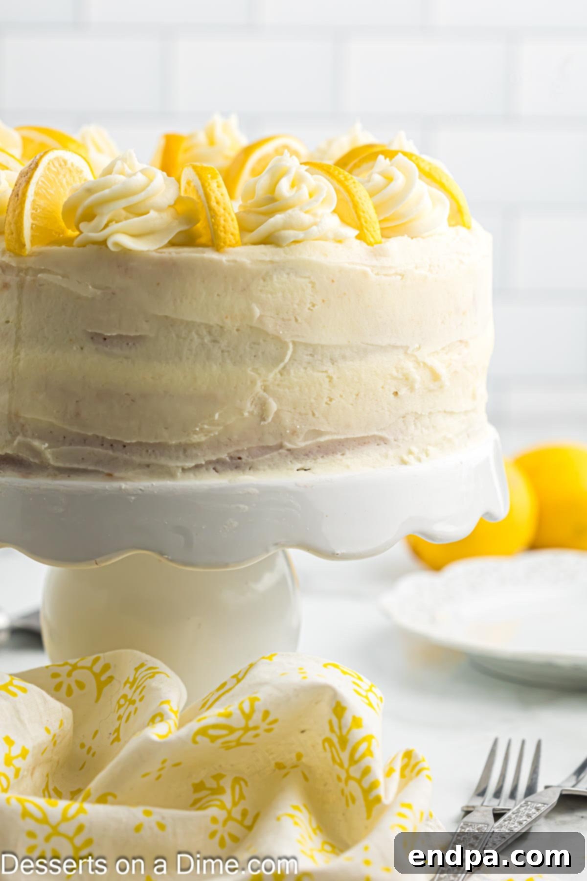 Sunshine Lemon Cake 8 Fully assembled and frosted lemon cake on a cake stand, garnished with lemon slices.