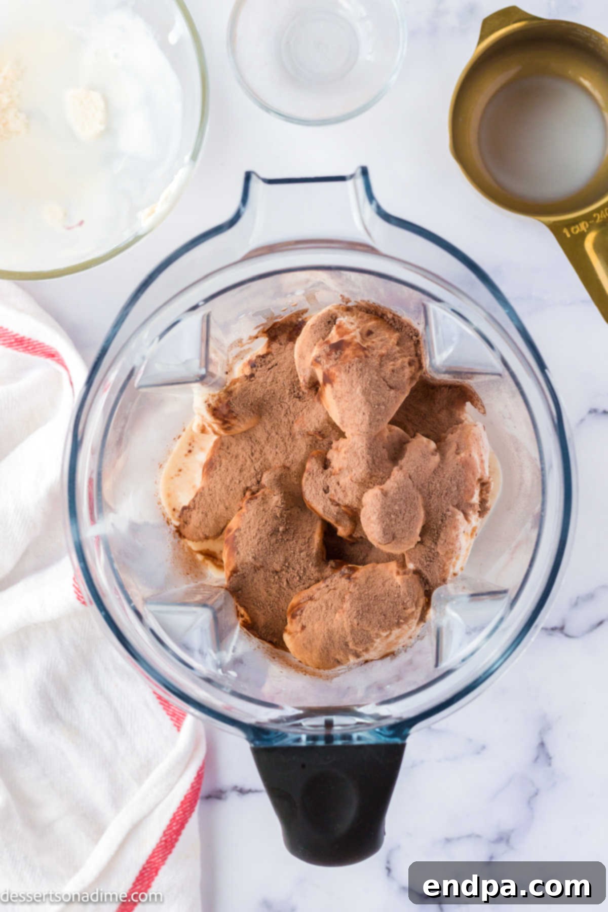 Crafting Your Own Wendy Frosty 4 Softened vanilla ice cream, milk, and Nesquik powder being added to a blender.