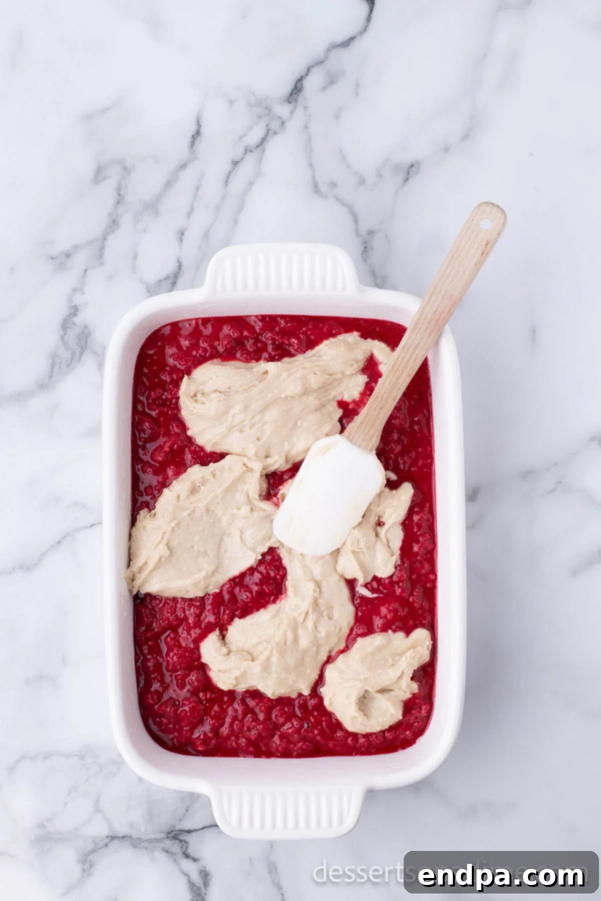 Topping spread over the raspberry filling.