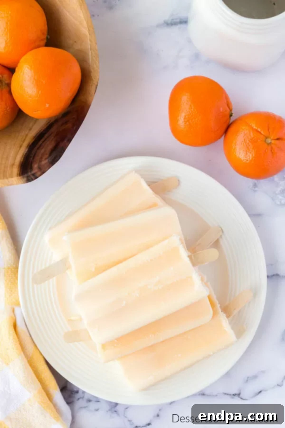 Several Orange Julius popsicles arranged neatly on a plate, ready to be enjoyed.