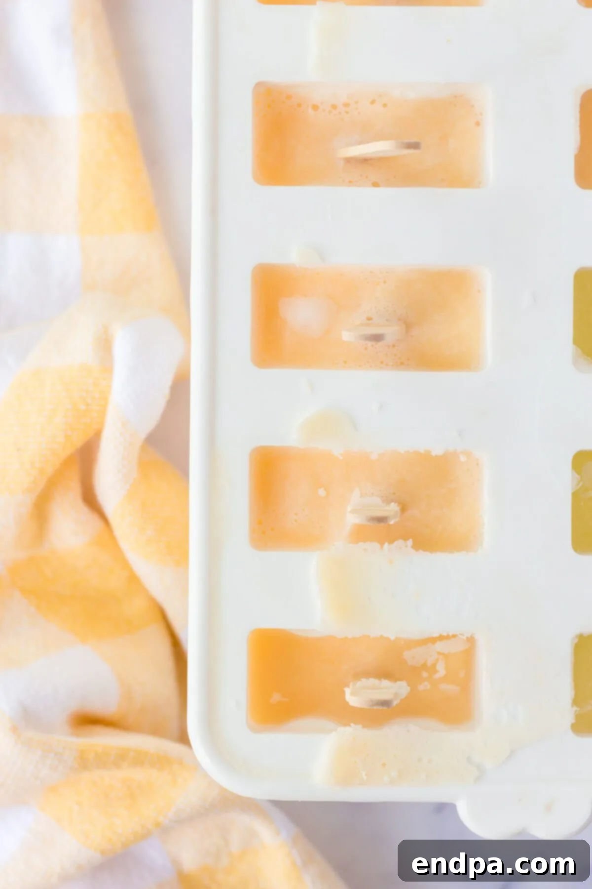 The orange mixture poured into popsicle molds and placed in the freezer to set.