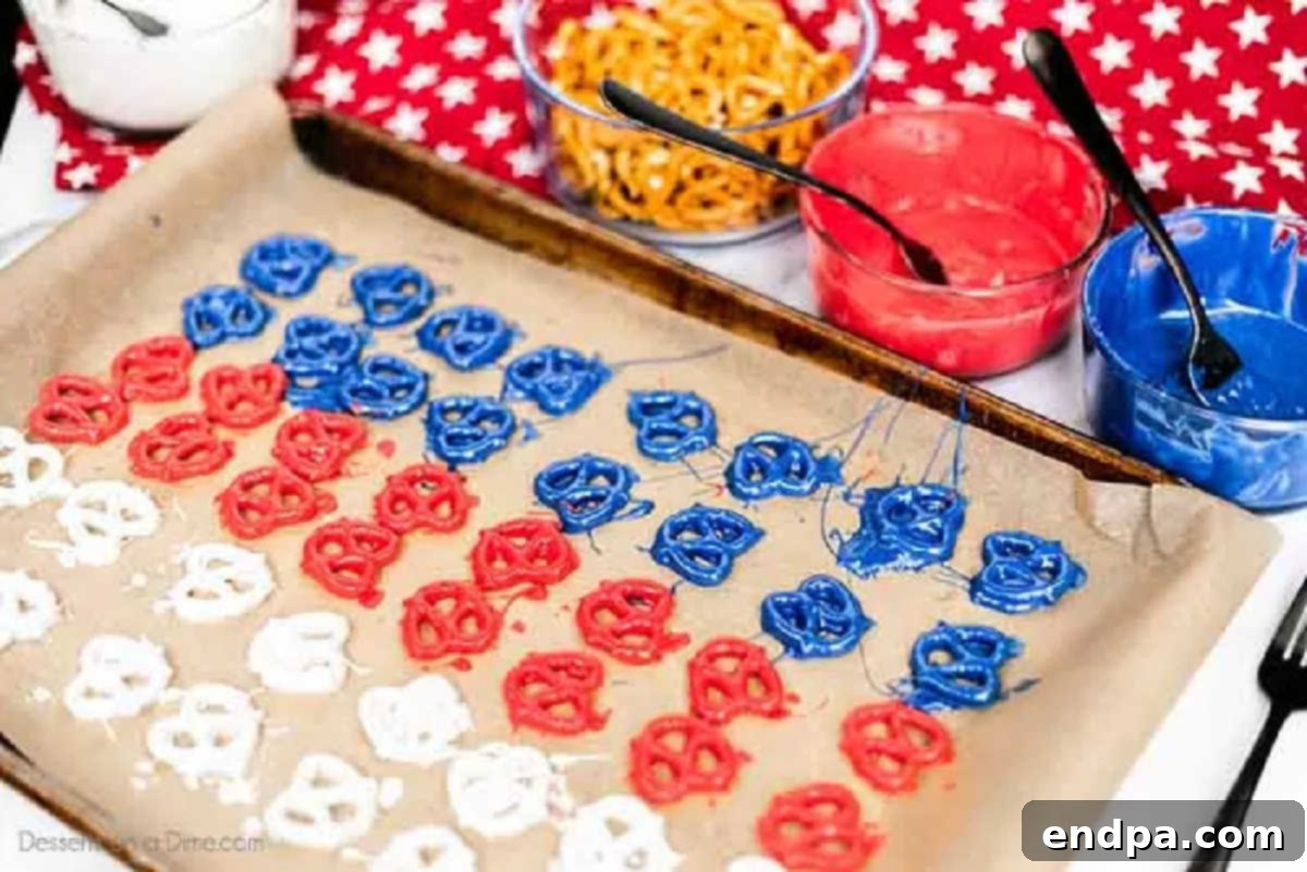Dipped pretzels arranged on a parchment-lined baking sheet.