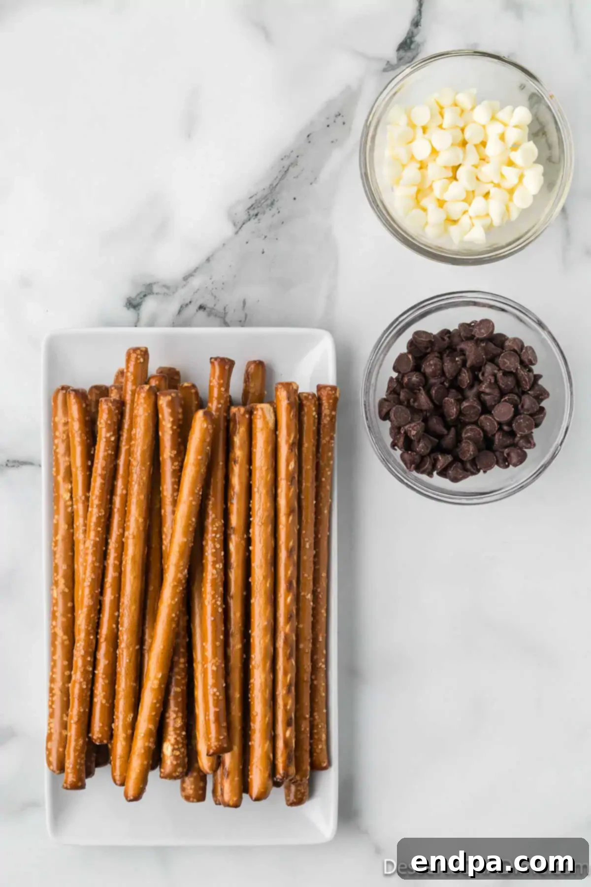 Ingredients for recipe - pretzel rods, white chocolate chips, semi-sweet chocolate chips.
