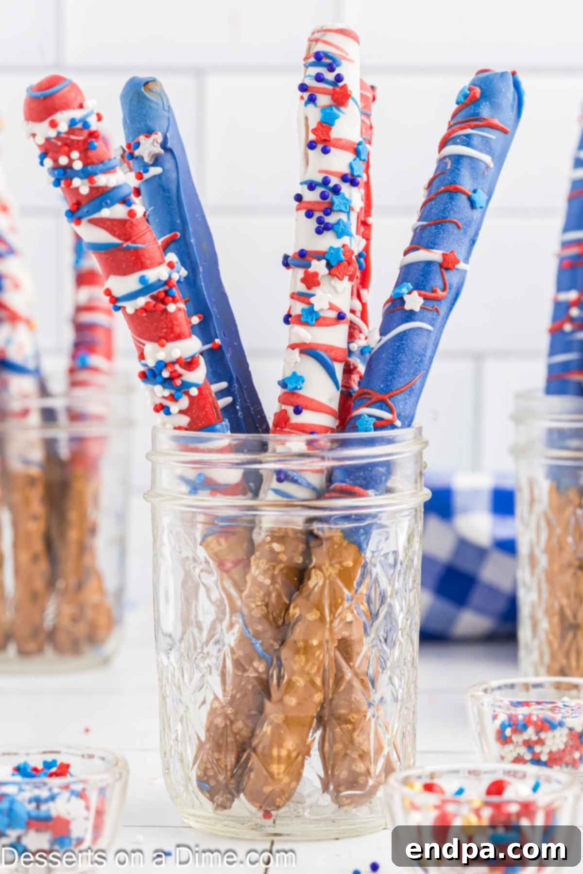 A plate of red, white, and blue chocolate covered pretzel rods, ready to be served for a 4th of July celebration.