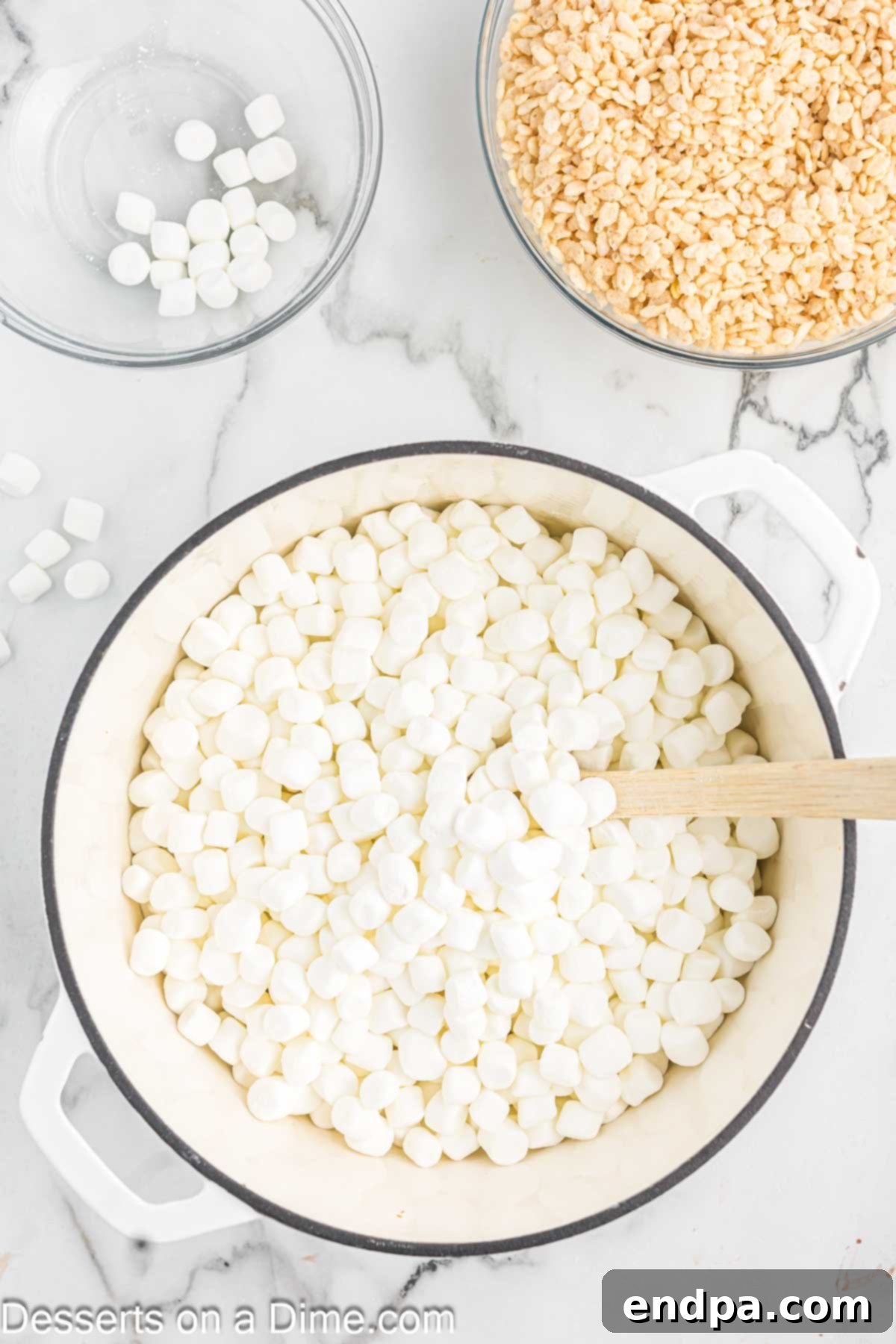 Crispy Marshmallow Bars 5 Fluffy white marshmallows being added to the melted butter in a saucepan.