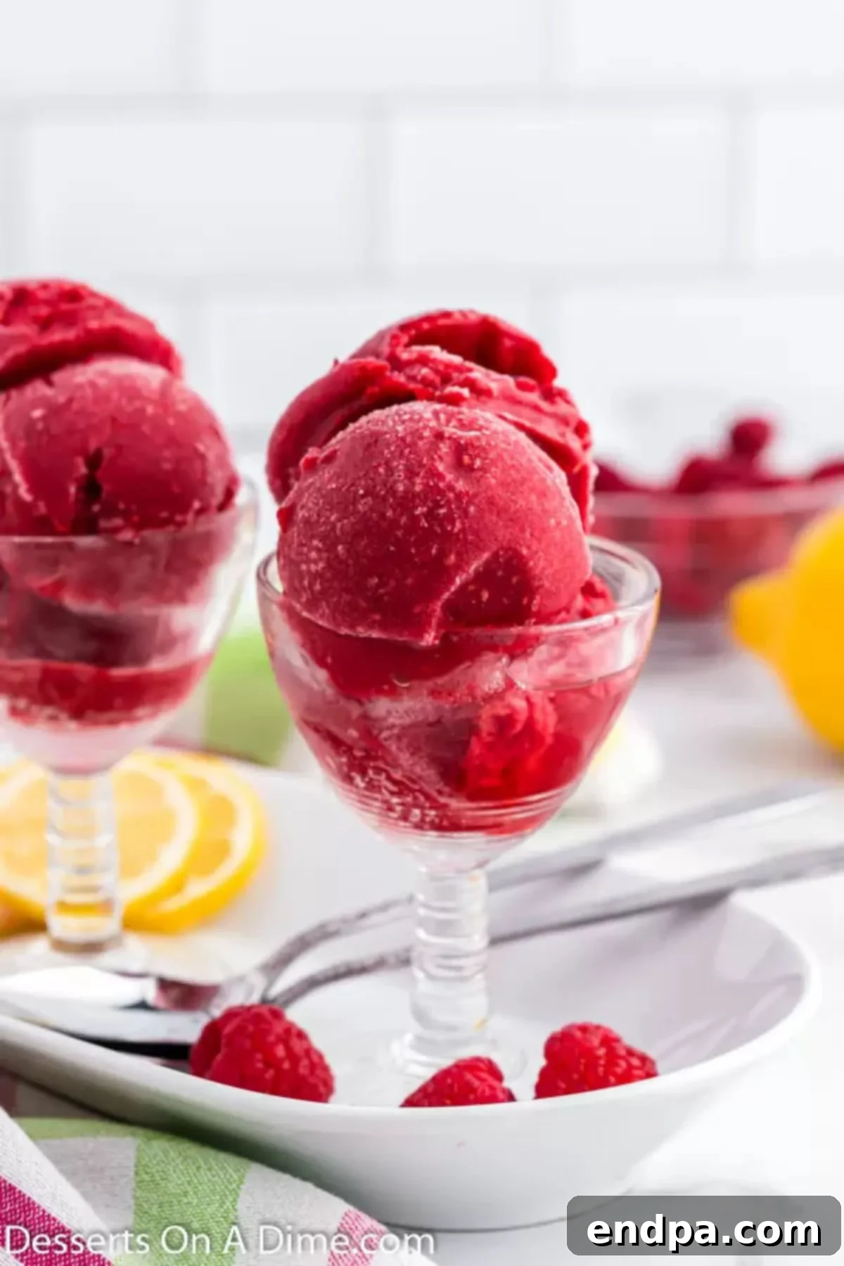 Tangy Raspberry Delight 2 A bowl of vibrant pink Raspberry Sorbet with fresh raspberries and a spoon, ready to be enjoyed.