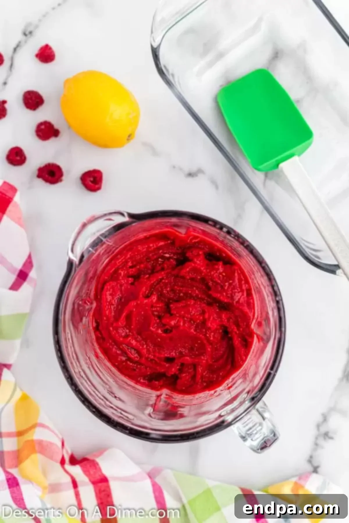 Tangy Raspberry Delight 4 Close-up of frozen raspberries, honey, and lemon juice being blended into a smooth puree in a high-speed blender.