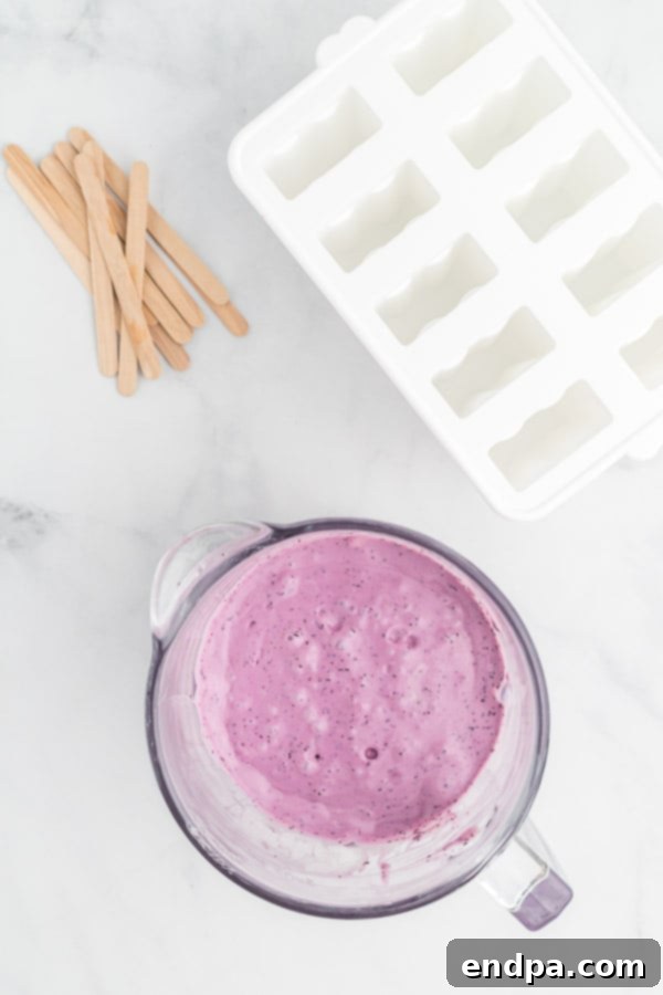 Healthy & Delicious Greek Yogurt Popsicles 4 All ingredients - Greek yogurt, fruit, and honey - combined and blended into a smooth, colorful mixture in a blender.