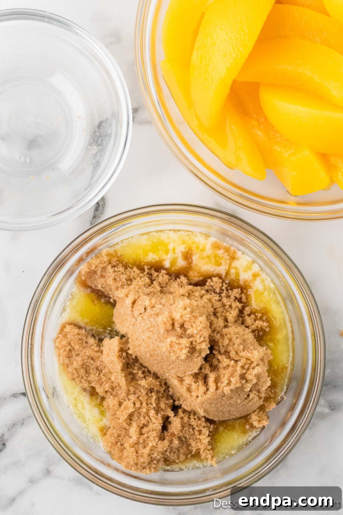 A brown sugar and melted butter mixture combined in a bowl, forming a rich, sticky topping.