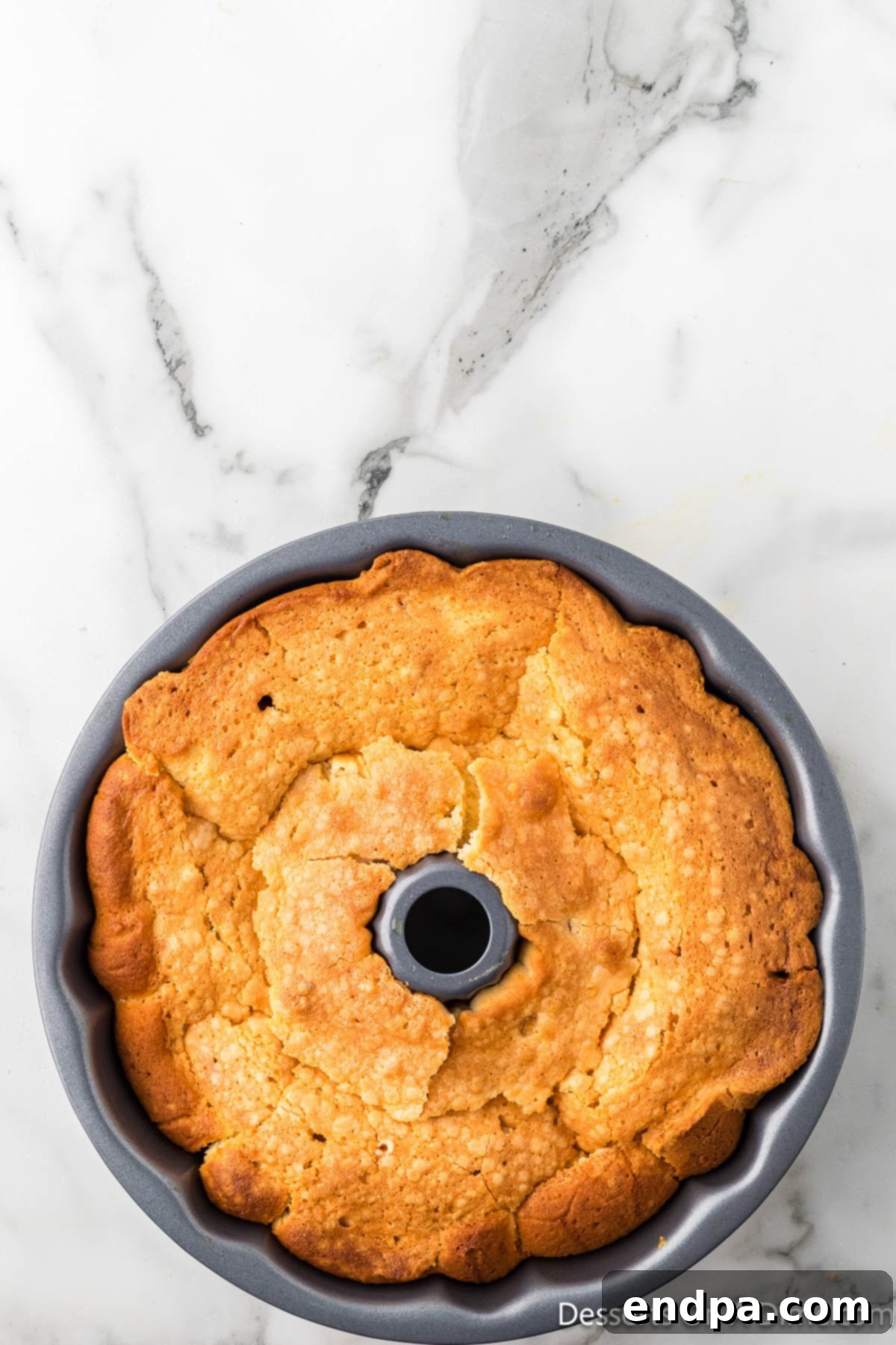 A freshly baked Peach Cobbler Pound Cake cooling in its bundt pan on a wire rack.