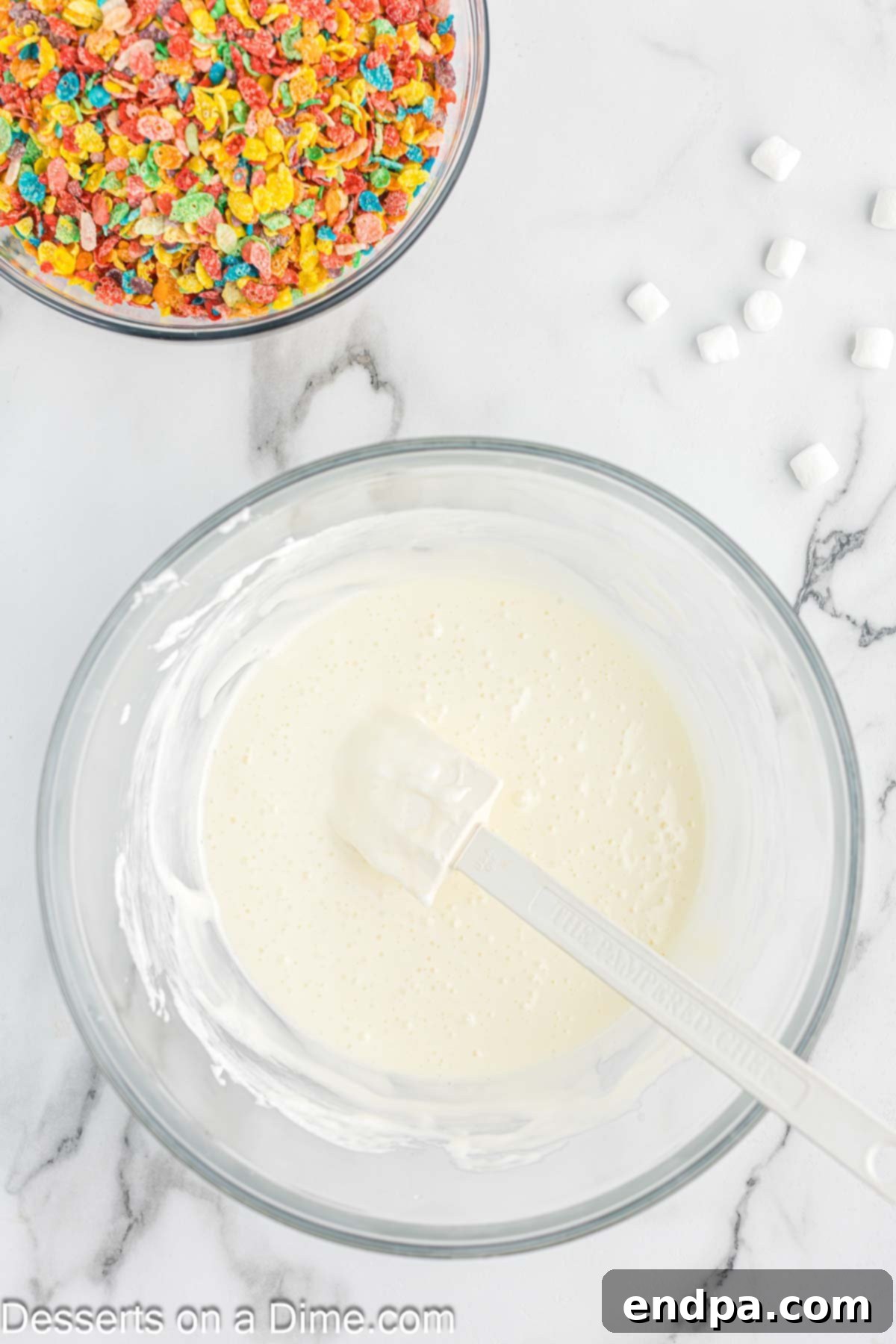 Bowl of butter and mini marshmallows melted and stirred together to create a smooth, gooey mixture.