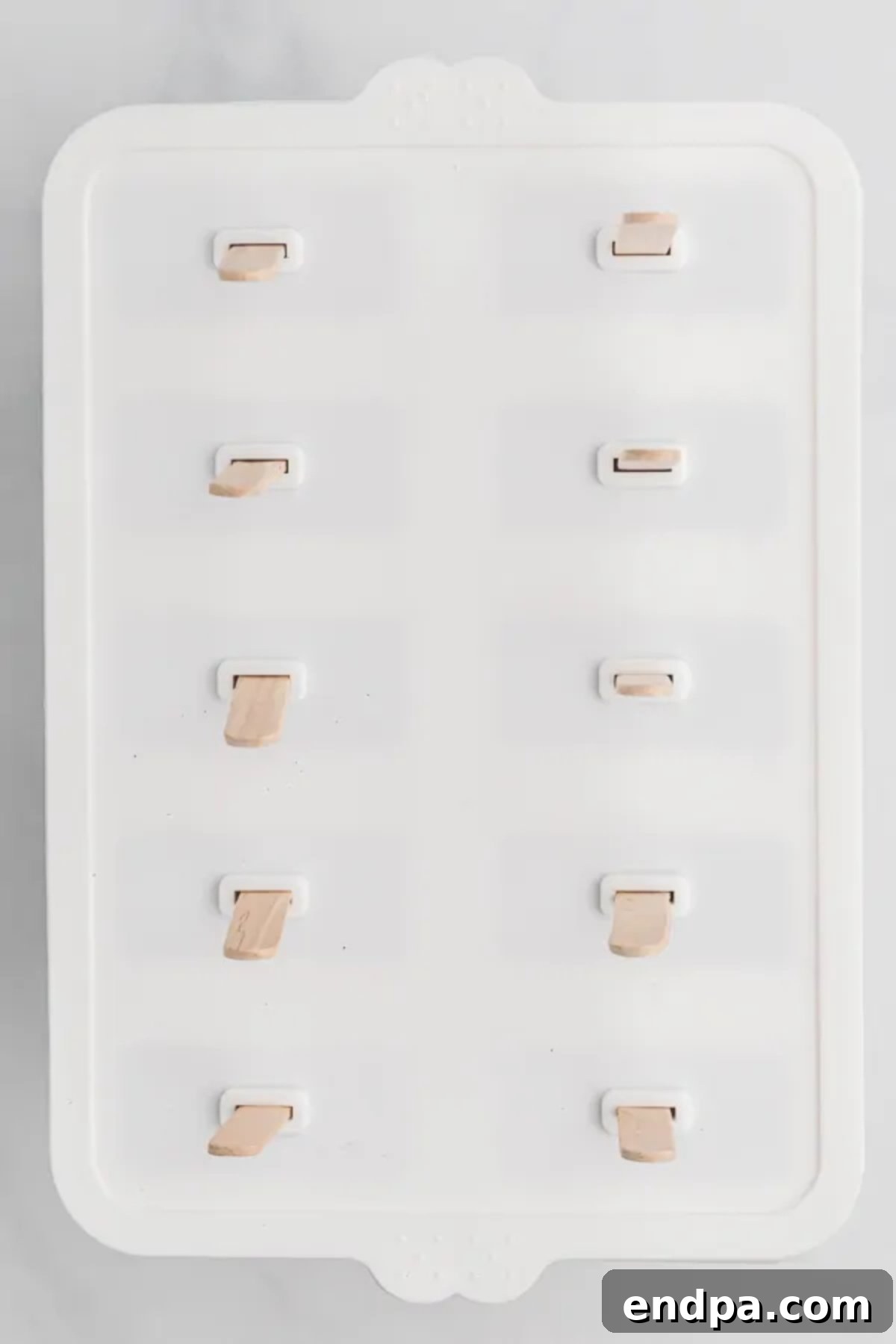 Refreshing Blueberry Yogurt Pops 6 Popsicle sticks being inserted into the filled molds.