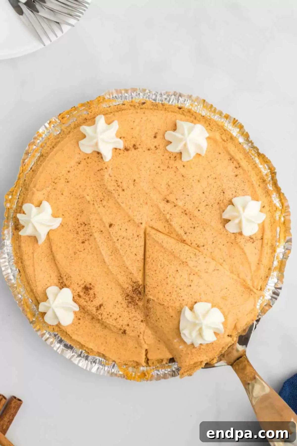 A No Bake Pumpkin Pie generously dolloped with whipped cream and ready to be served.