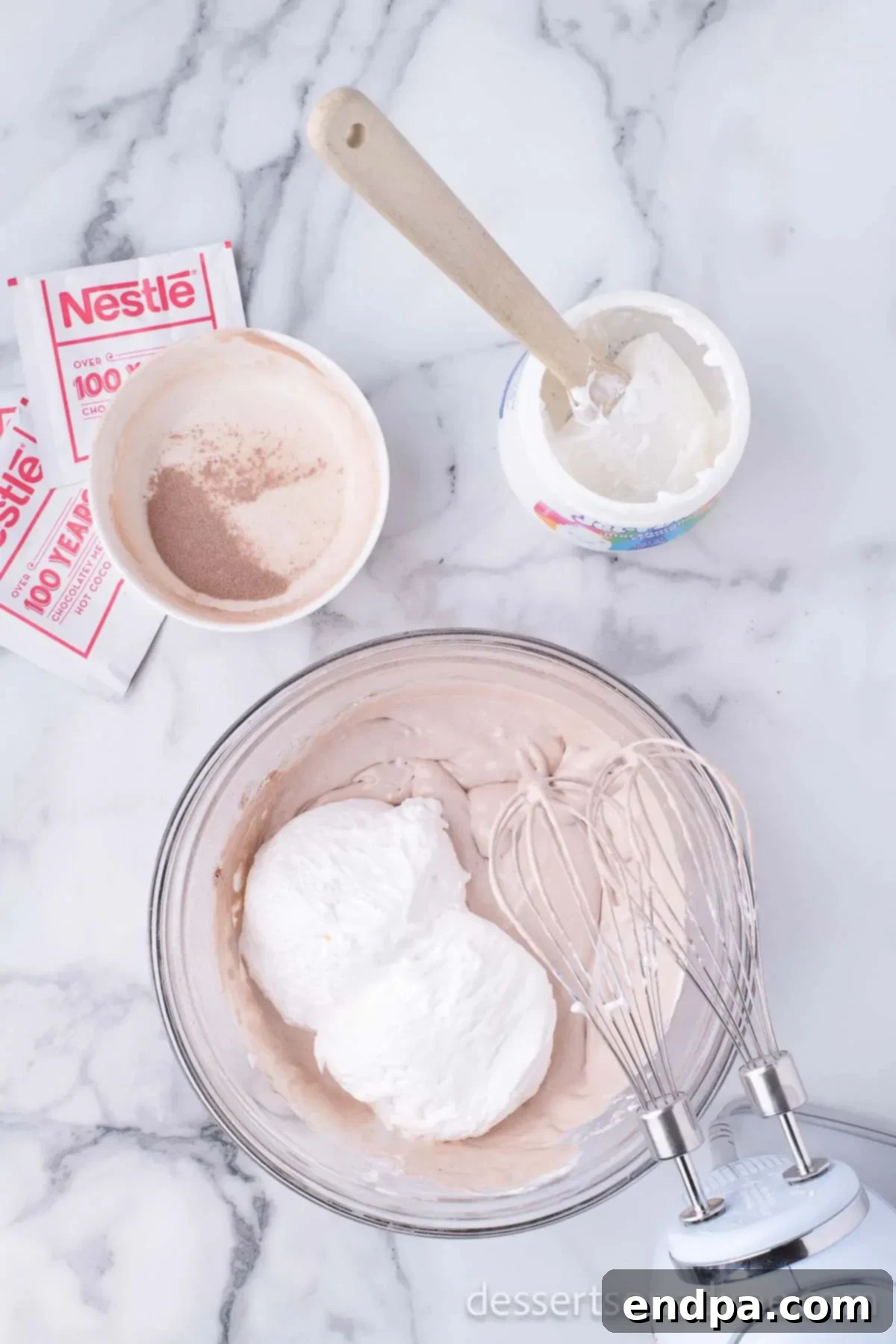 Decadent Hot Chocolate Dip 3 Combining marshmallow creme, Cool Whip, and hot cocoa mix in a large mixing bowl, ready to be blended.