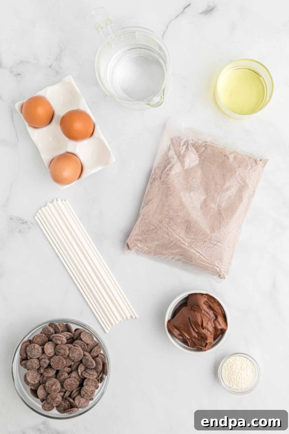 Ingredients for homemade chocolate cake pops: chocolate cake mix, chocolate fudge frosting, candy melts, sprinkles, and lollipop sticks.