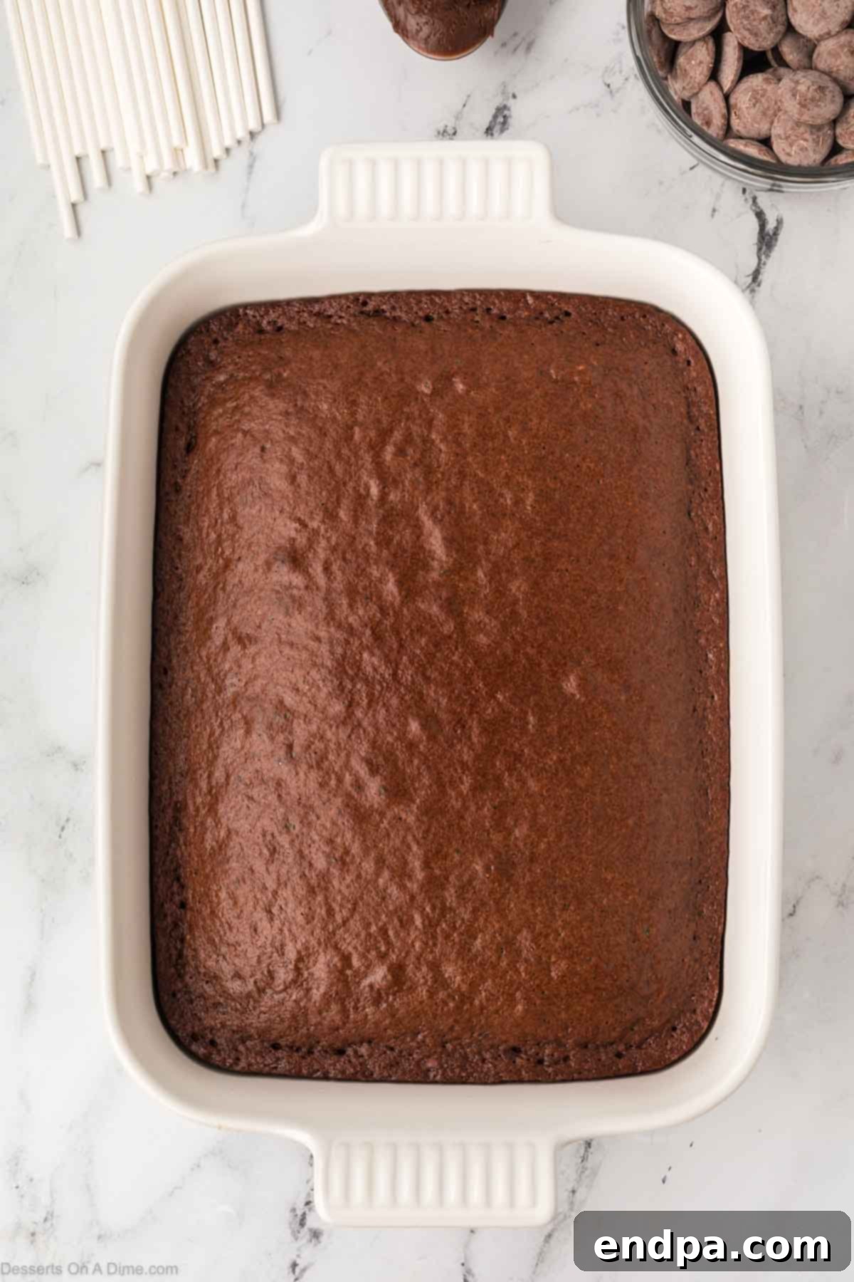 Chocolate cake baked and cooling in a 9x13 pan.