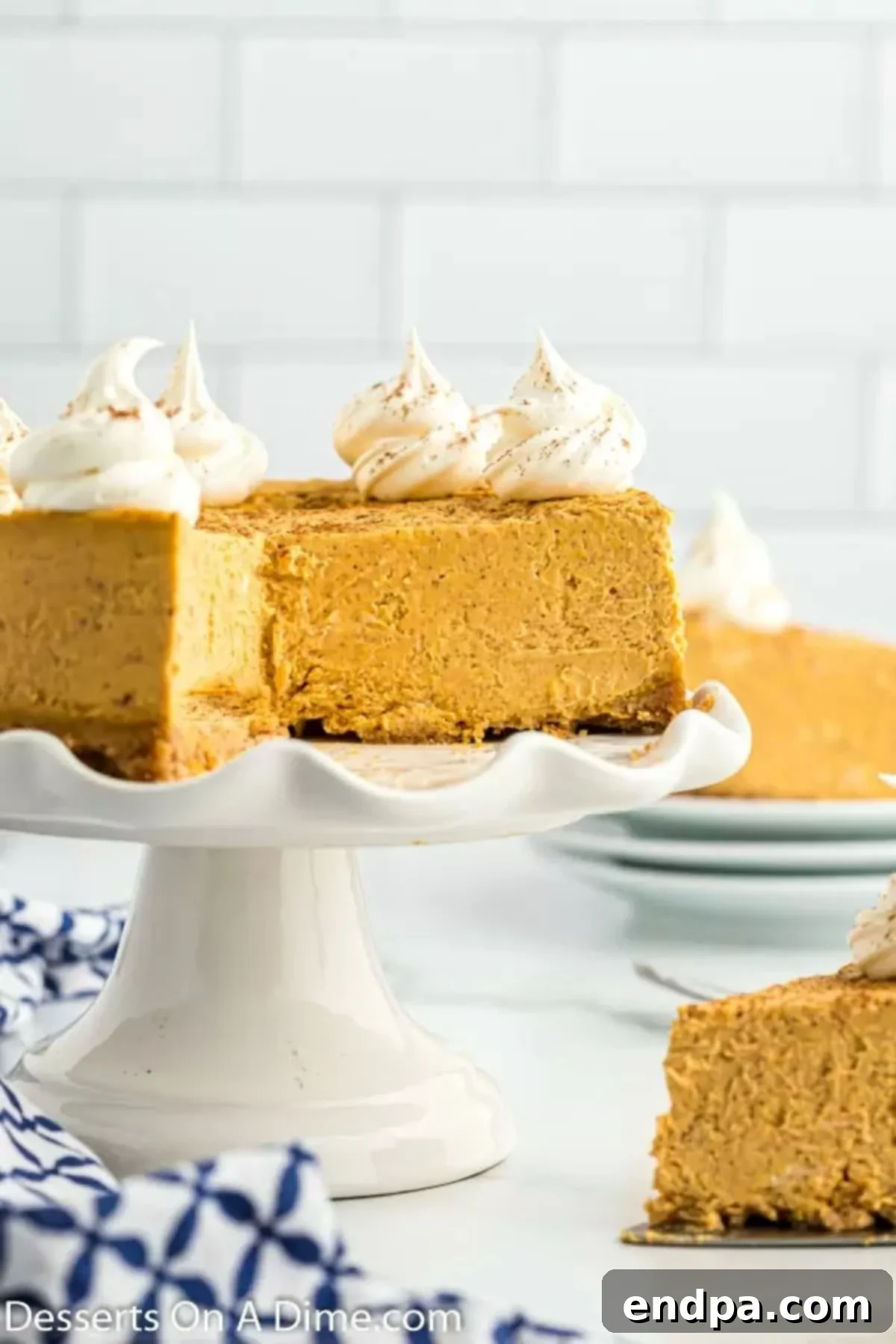 Instant Pot Pumpkin Cheesecake served beautifully on a cake stand, showcasing its smooth texture and golden-brown crust.