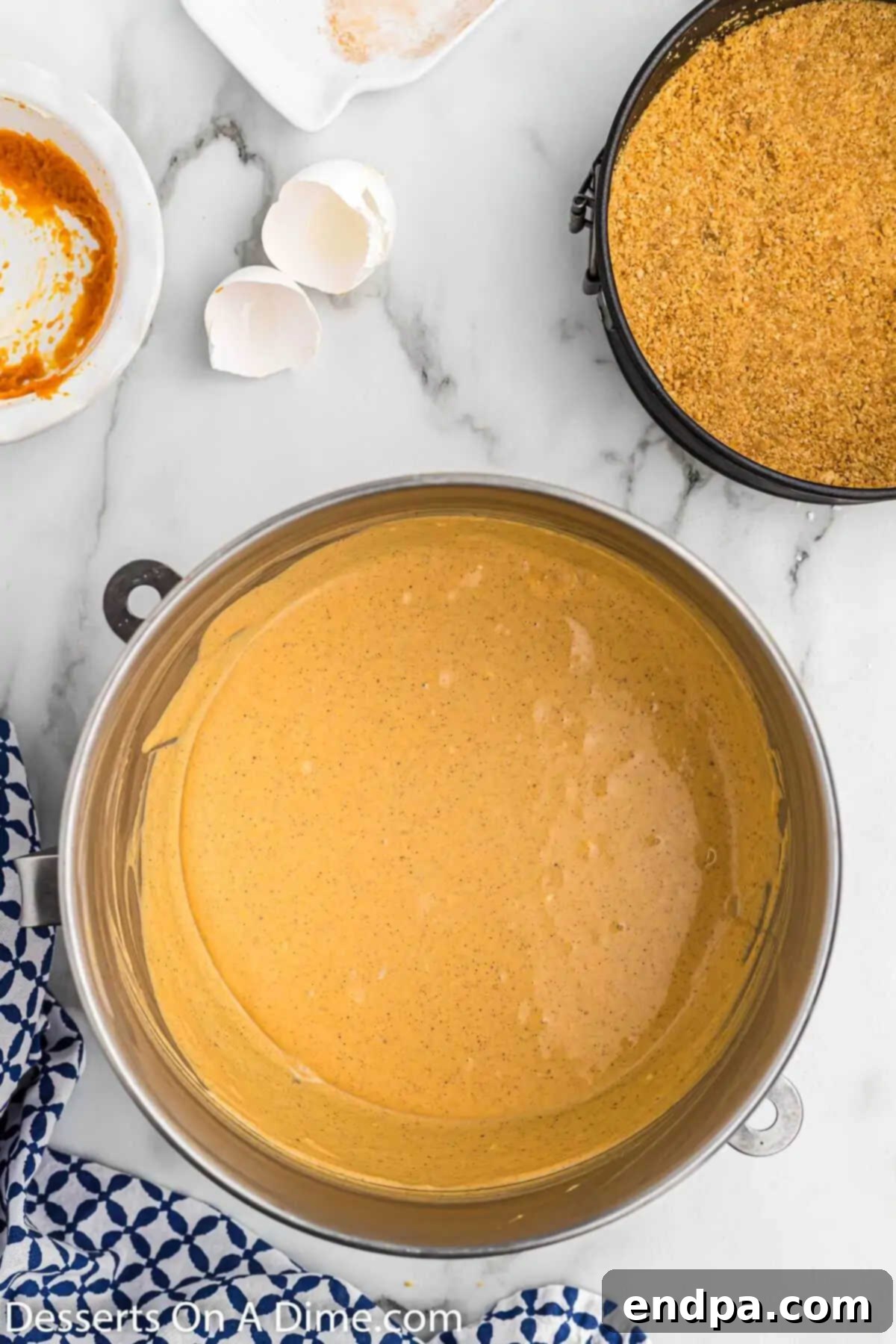 A large mixing bowl filled with the creamy pumpkin cheesecake batter, vibrant with autumn colors.