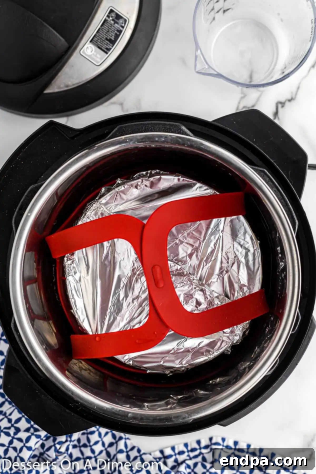 A metal trivet placed inside the Instant Pot liner, ready to hold the springform pan.